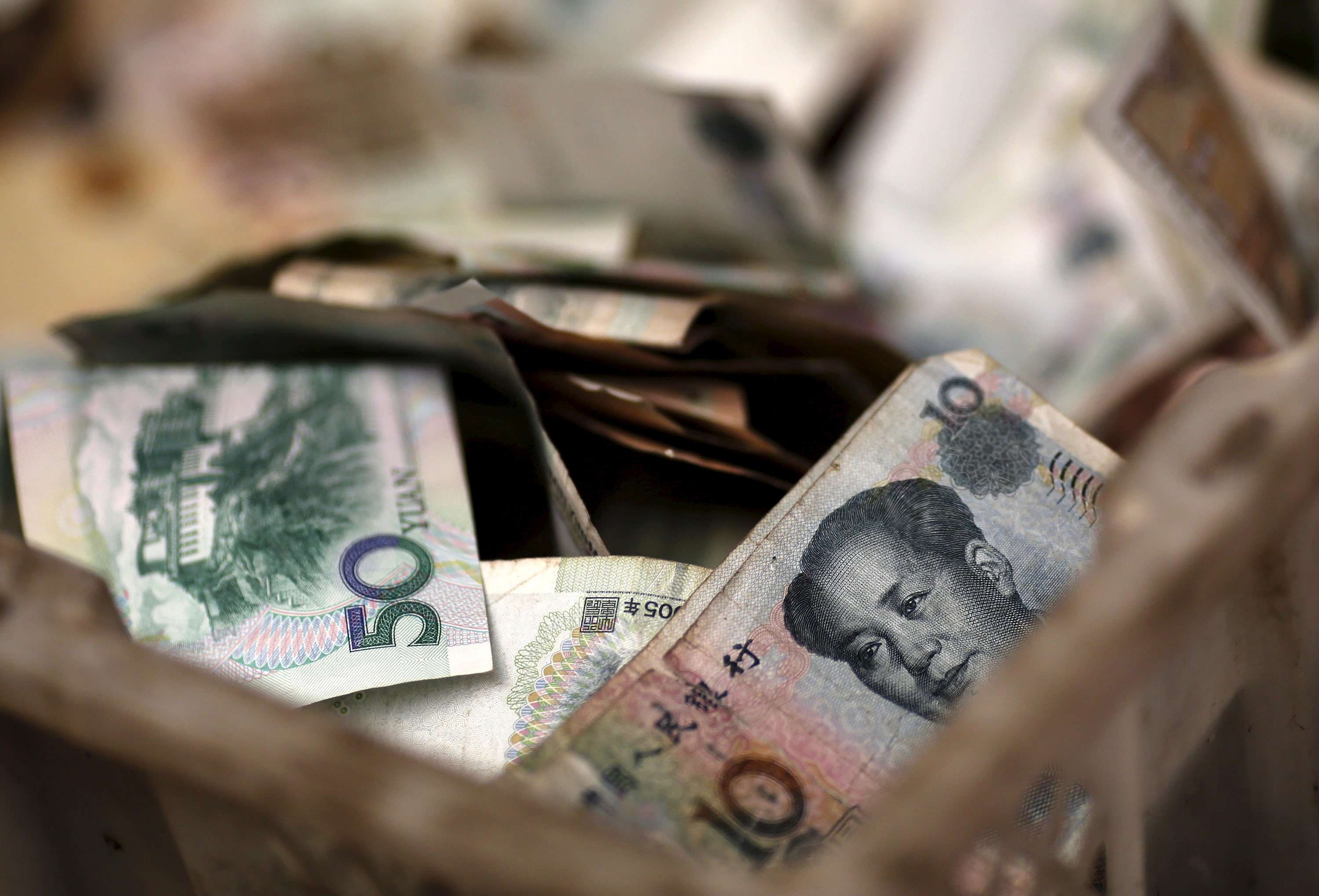 Chinese banknotes are seen in a vendor's cash box at a market in Beijing. China’s renminbi is closer to joining the major league of reserve currencies with a deal to include it in the International Monetary Fund's unit of account. Photo: Reuters