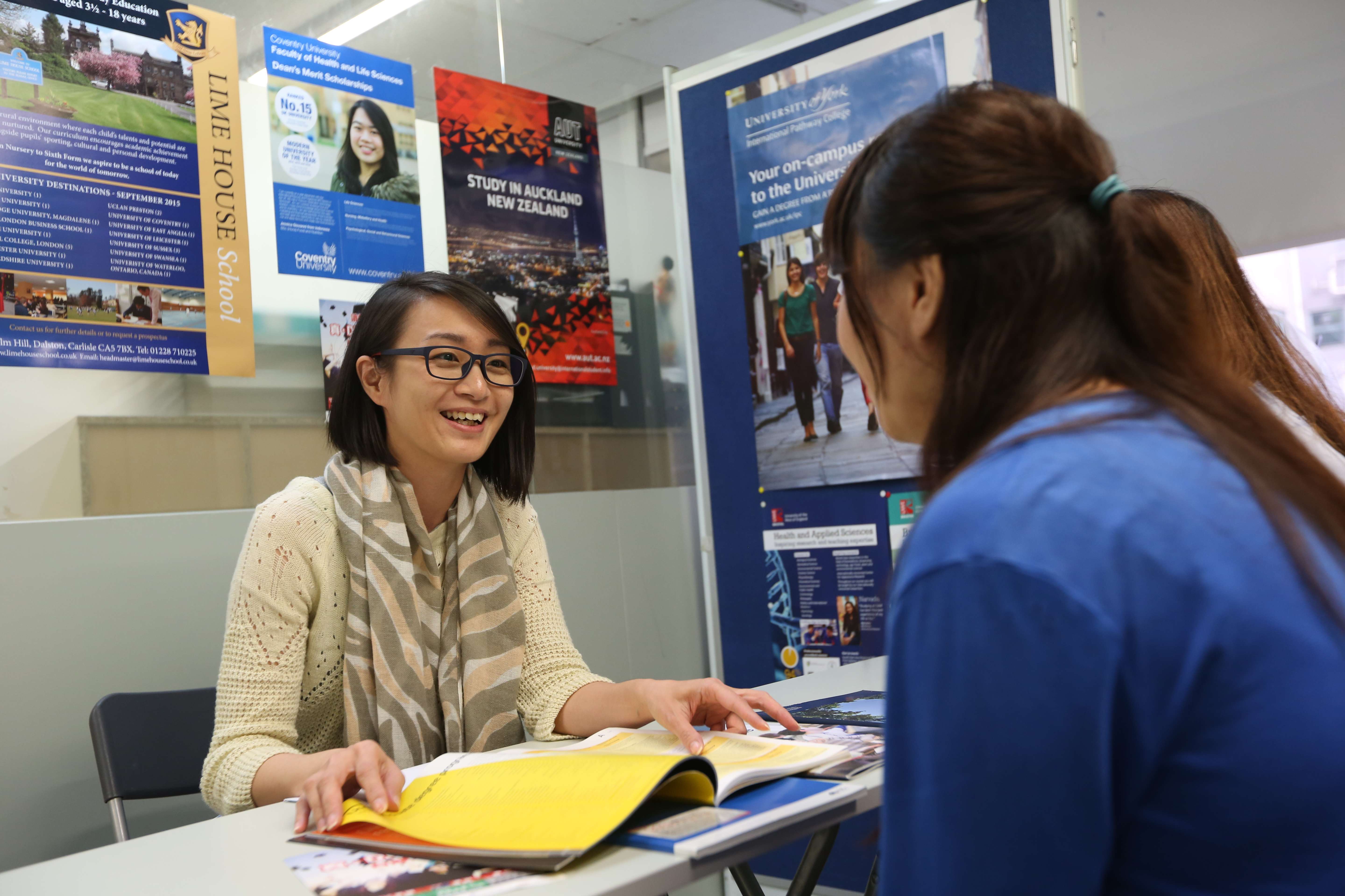 Yetta Kwan (left), senior education consultant, answers questions from students and parents who seek advice for studying abroad at AAS Education Consultancy in Mong Kok. Photo: Nora Tam