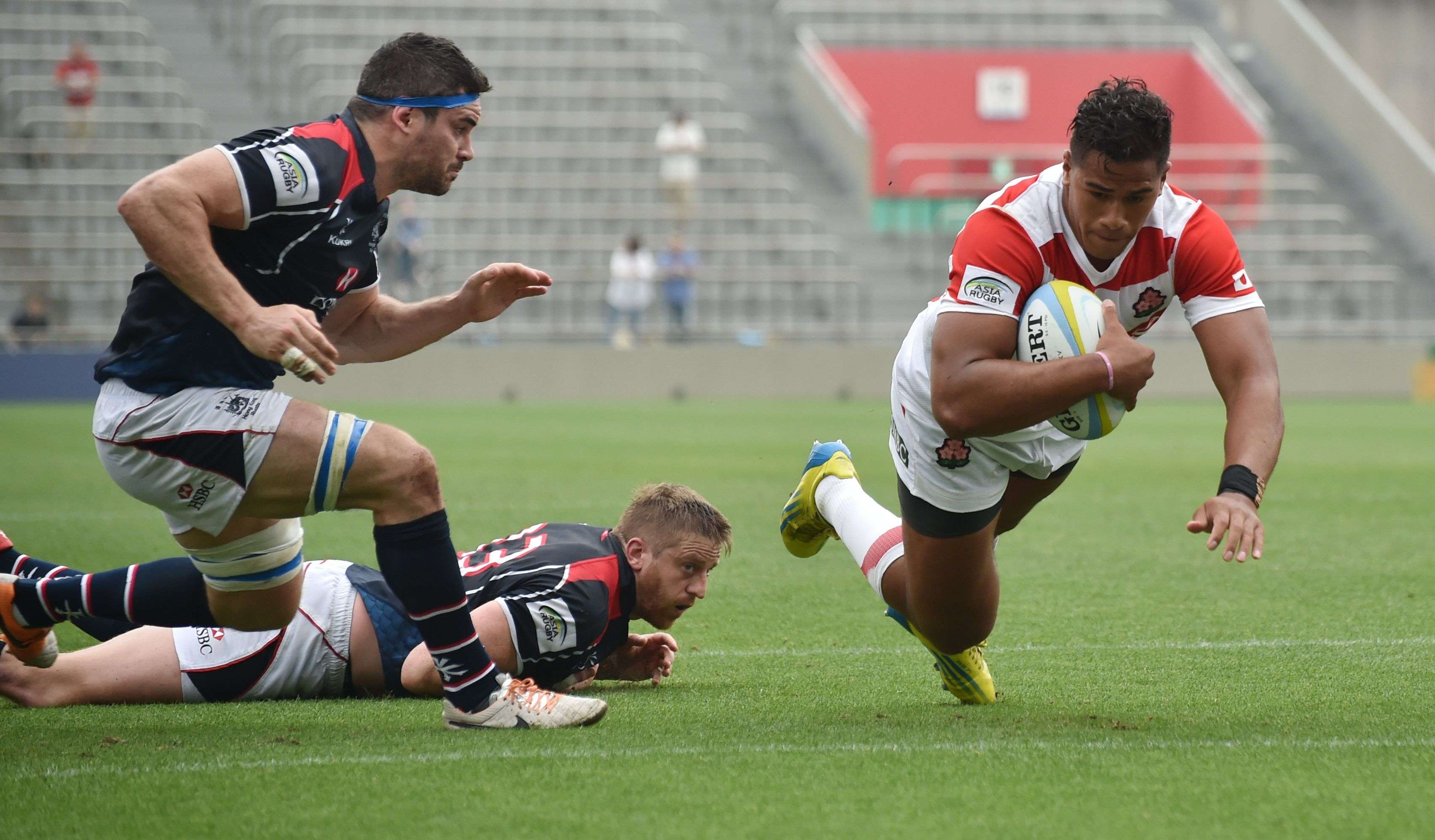 Hong Kong flanker Matthew Lamming can’t prevent Japan winger Ataata Moeakiola diving in for a try in their Asia Rugby Championship match in Tokyo. Photos: AFP