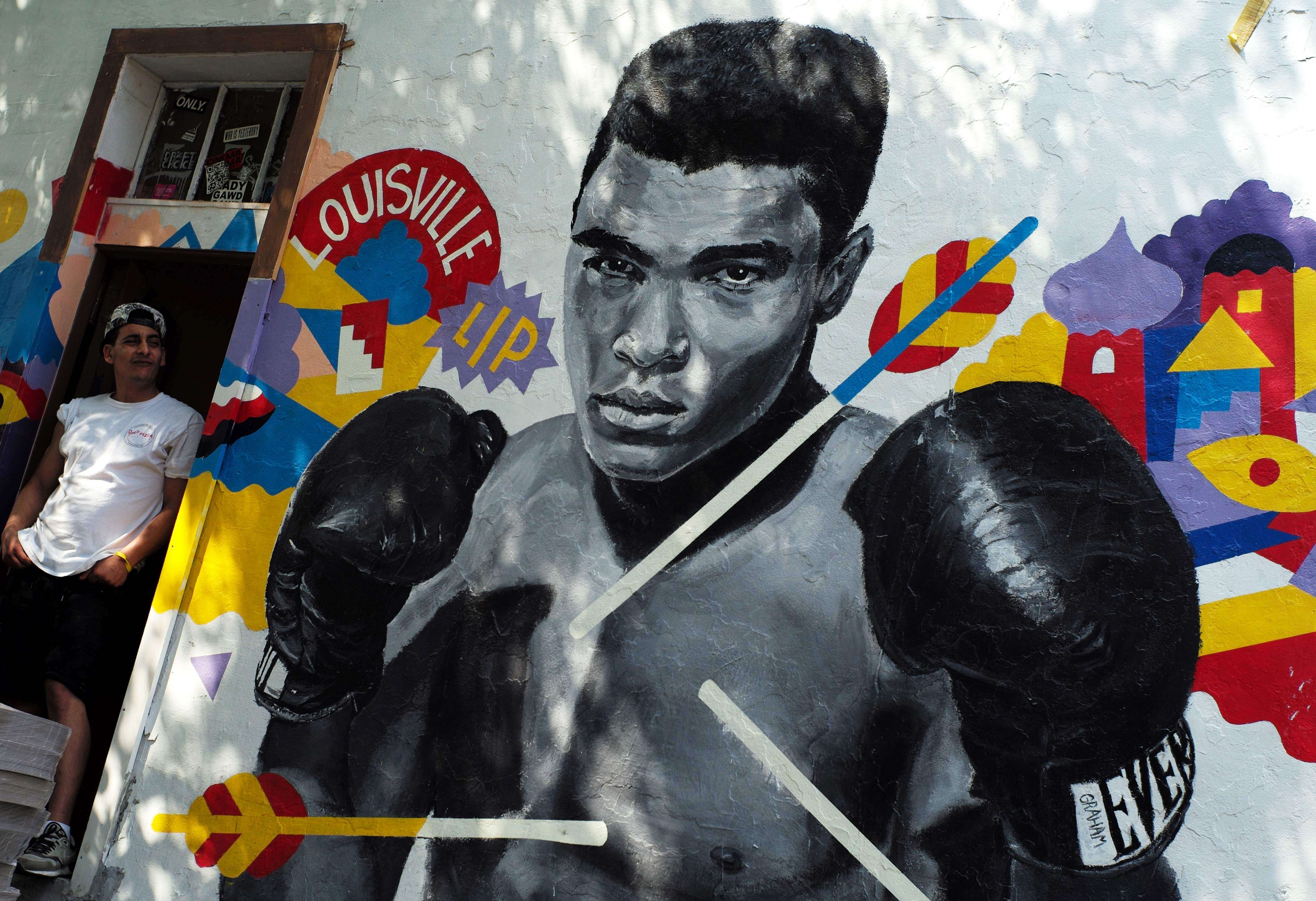 A man stands next to a mural of boxer Muhammad Ali in New York on Saturday. Photo: AFP