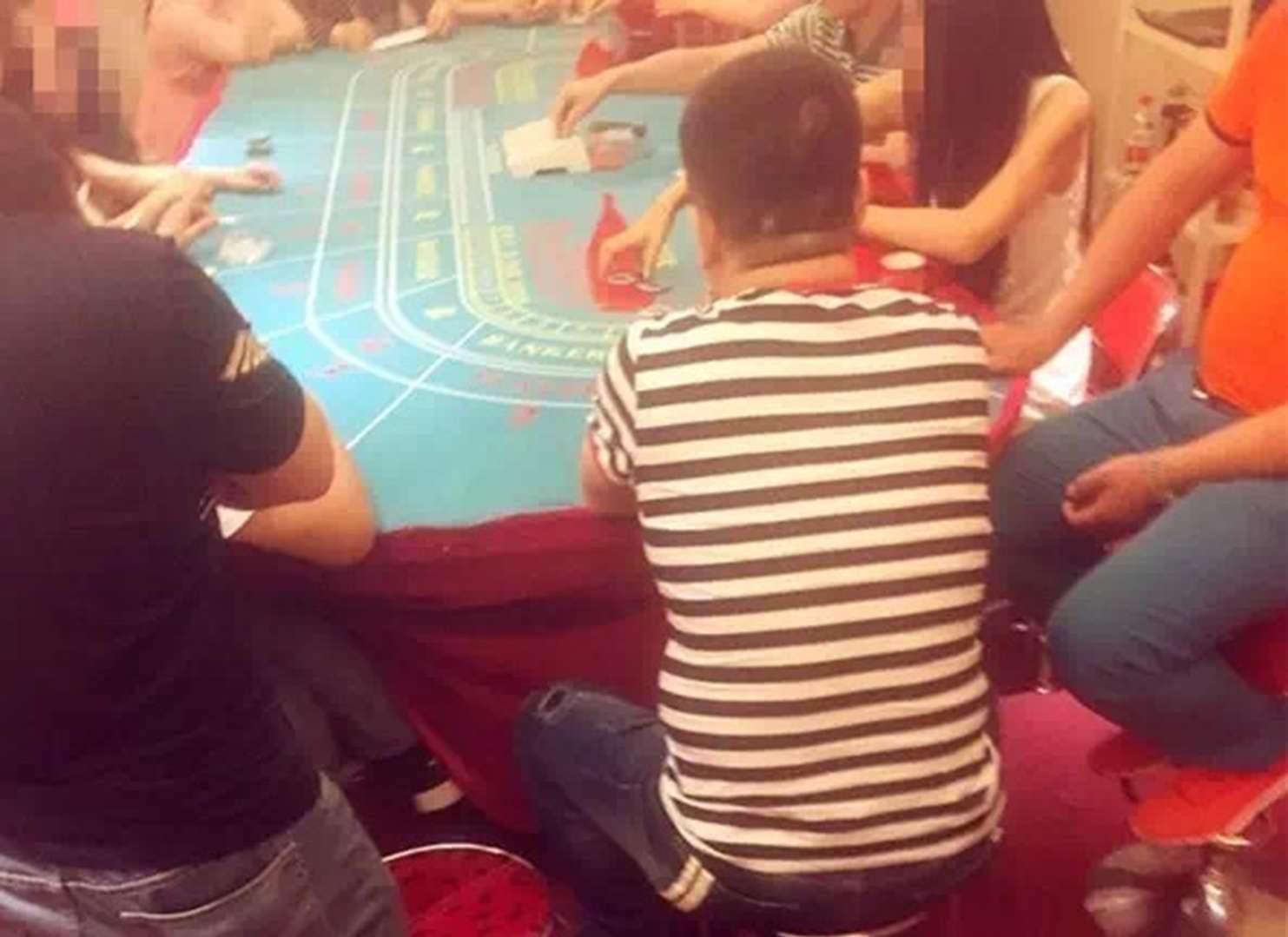Gamblers playing at the illegal poker den. Photo: The Beijing News