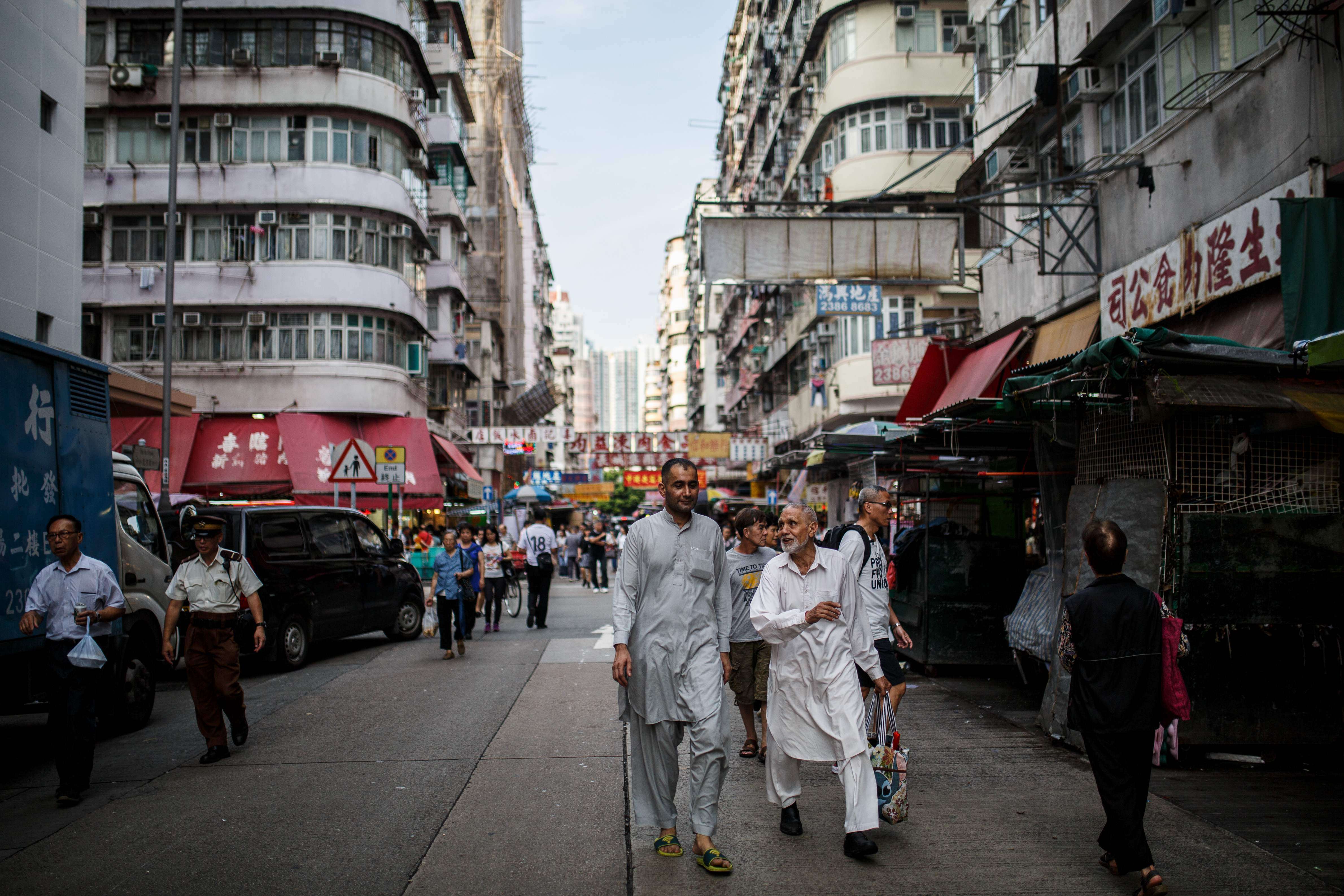 Pedestrians walk along a road in Kowloon. Hong Kong’s geographic position on the edge of China and at the centre of Asia is the result of strategic design. Photo: AFP