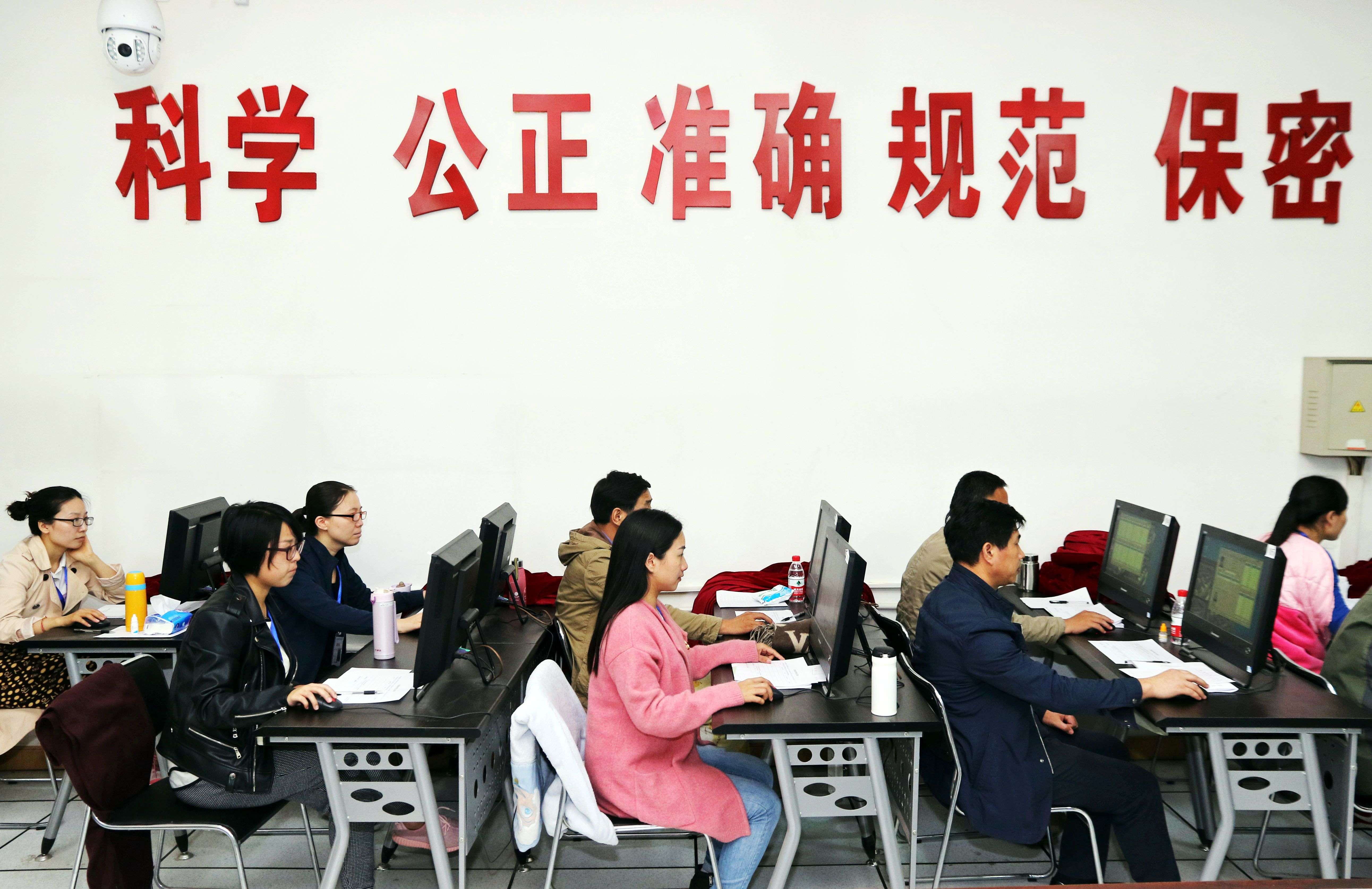 China’s education officers monitor students taking their university entrance exam in Zhengzhou, Henan province, earlier this month. Photo: AFP