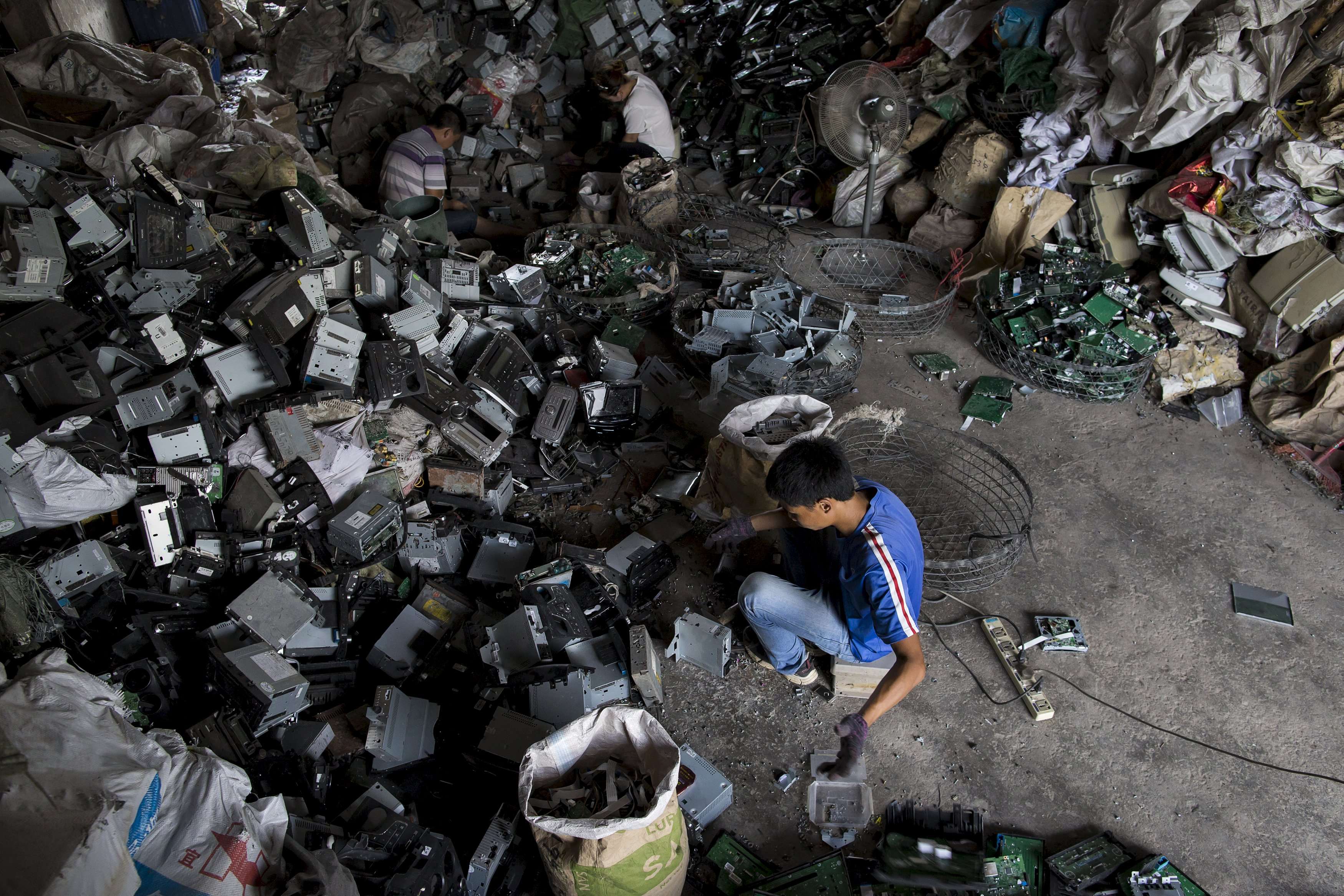 A worker recycles CD players at a workshop in Guiyu, in Guangdong. The town is known as one of the world’s largest electronic waste dump sites. Photo: Reuters