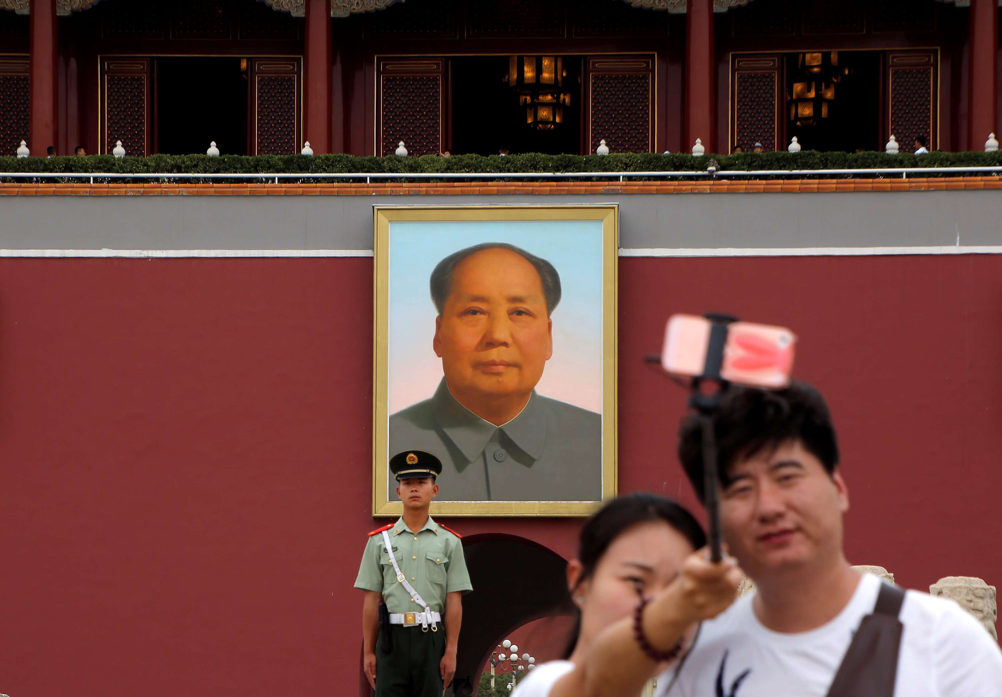 A couple take a selfie in front of a giant portrait of Mao at the Tiananmen gate in Beijing. Photo: Reuters
