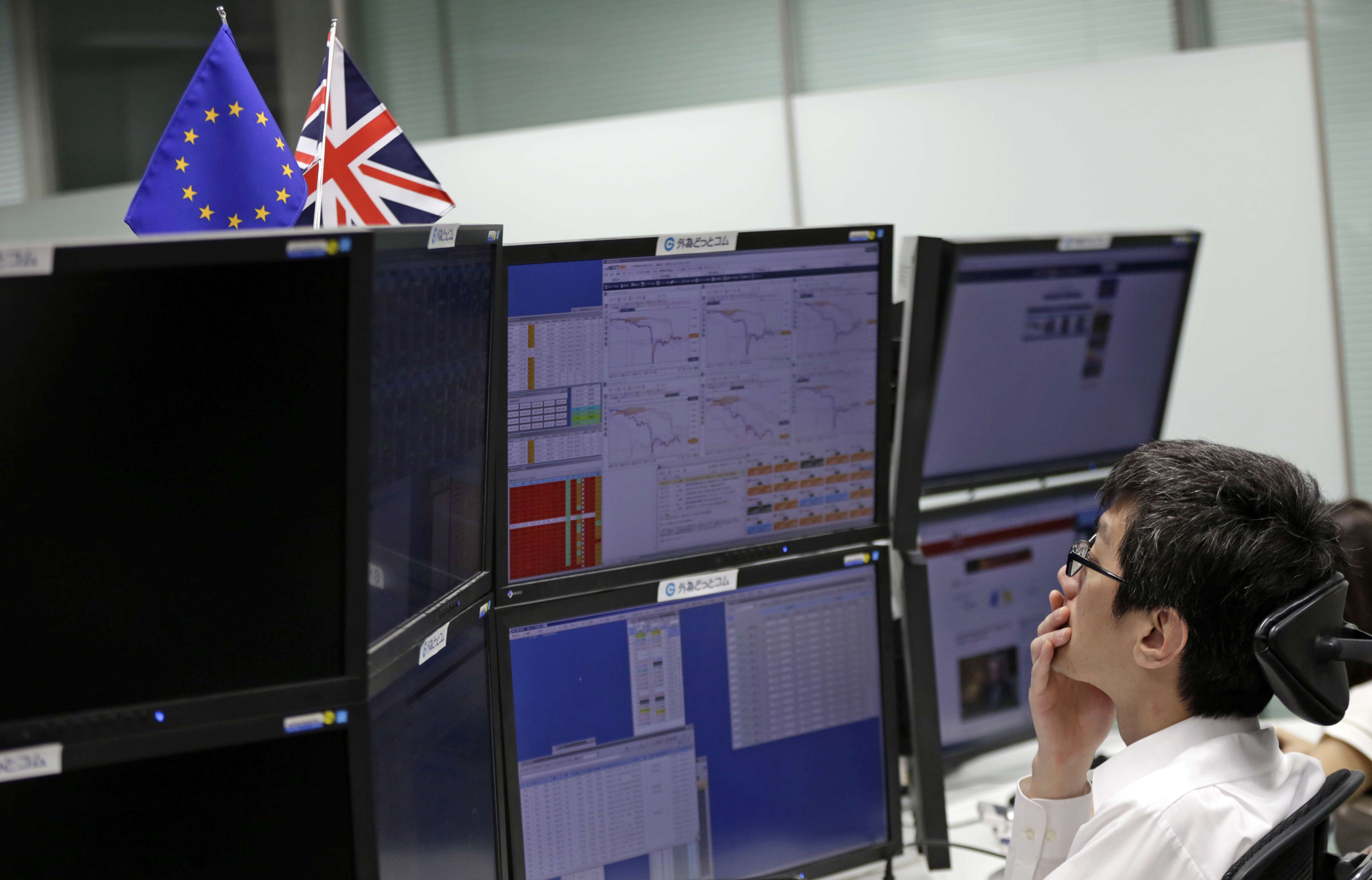 A money trader monitors computer screens at a securities firm in Tokyo on Friday, June 24. Photo: Eugene Hoshiko, AP