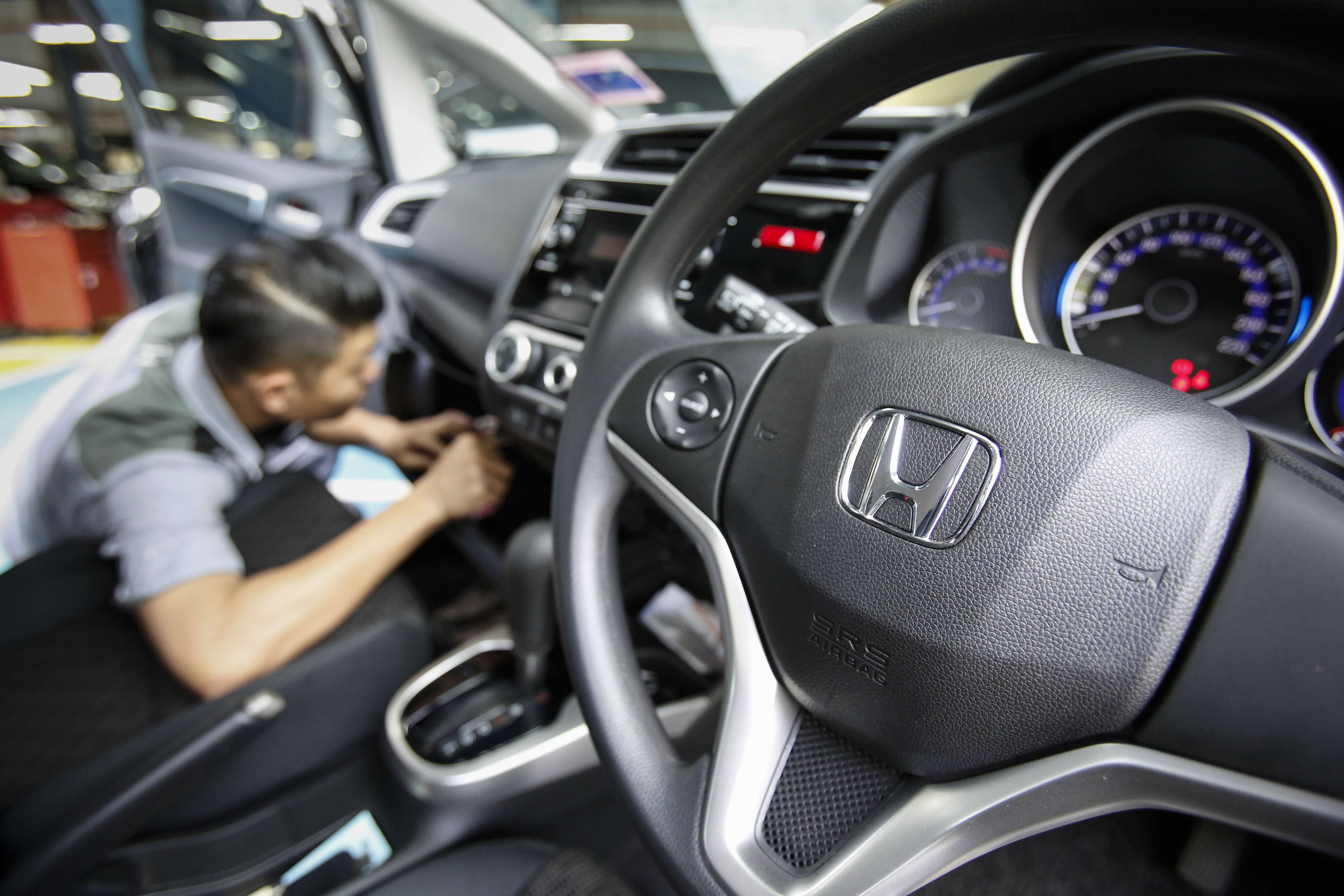 An automotive technician works on a Honda car at a service centre in Kuala Lumpur, Malaysia. Photo: AP