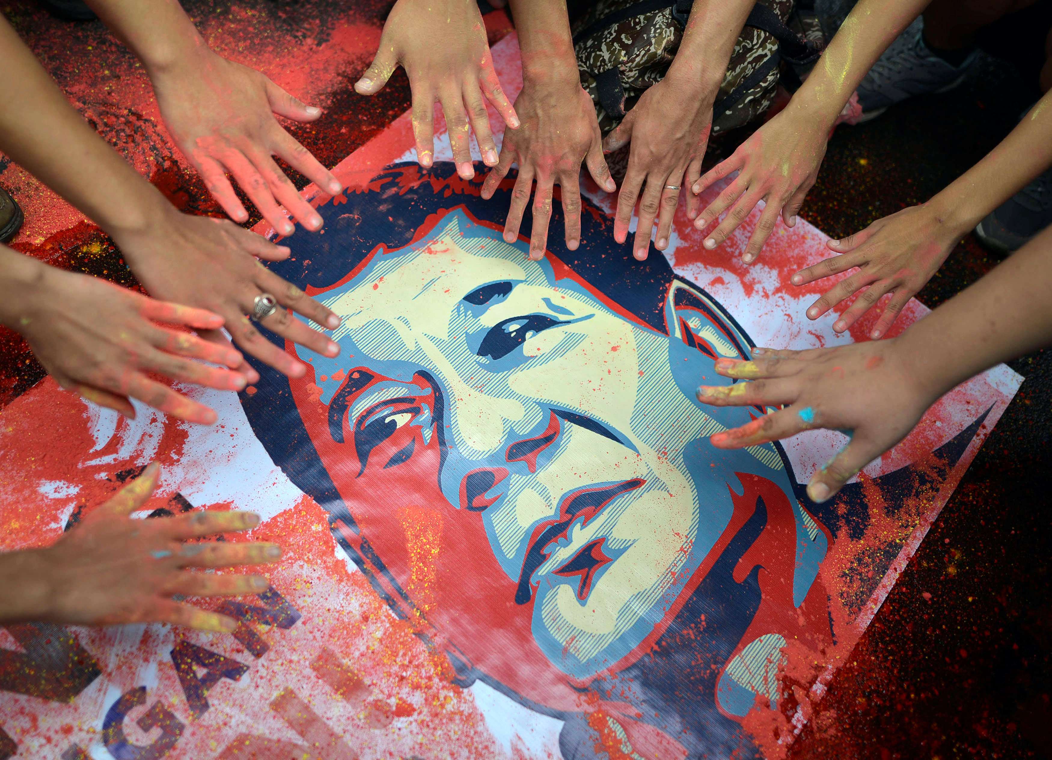 Activists with stained hands next to a portrait of Rodrigo Duterte, who was sworn as Philippine President on Thursday. Photo: Reuters