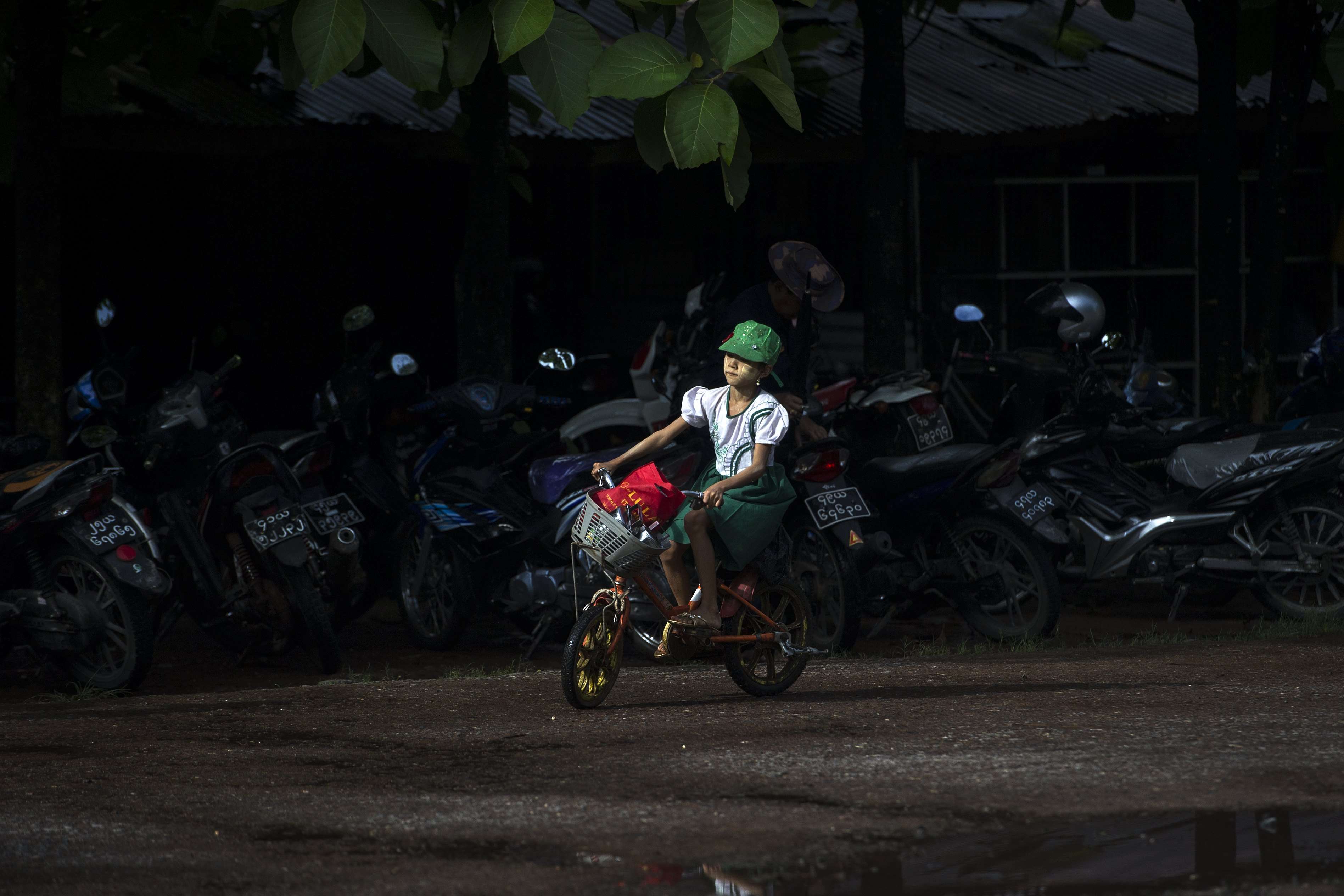 A schoolgirl rides her bike in Yangon. In Myanmar, just one fifth of the roads are paved. Photo: AFP