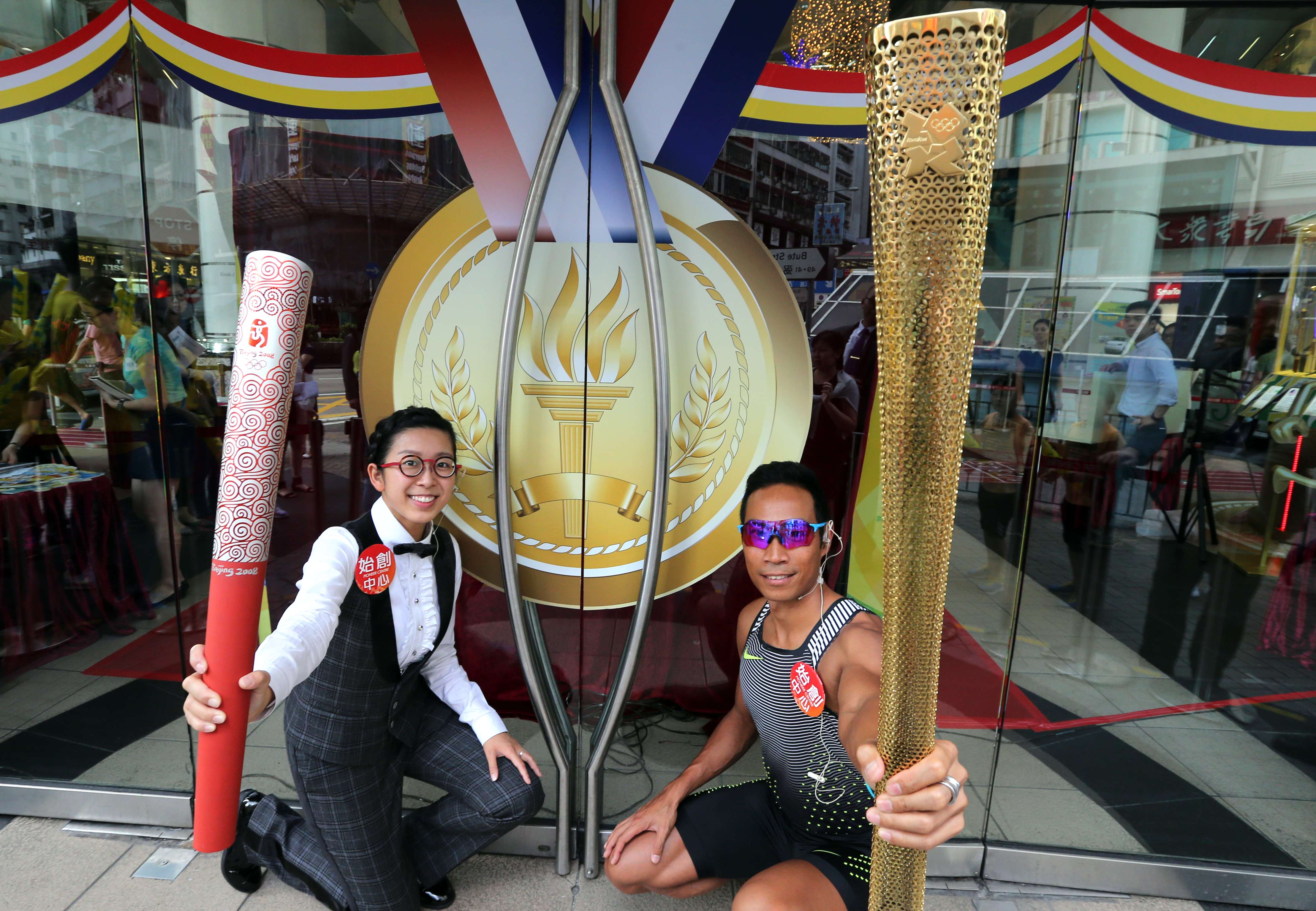 Ng On-yee, left, and Daniel Lee hold Olympic torches during an exhibition at the Pioneer Centre in Prince Edward. Photo: Felix Wong