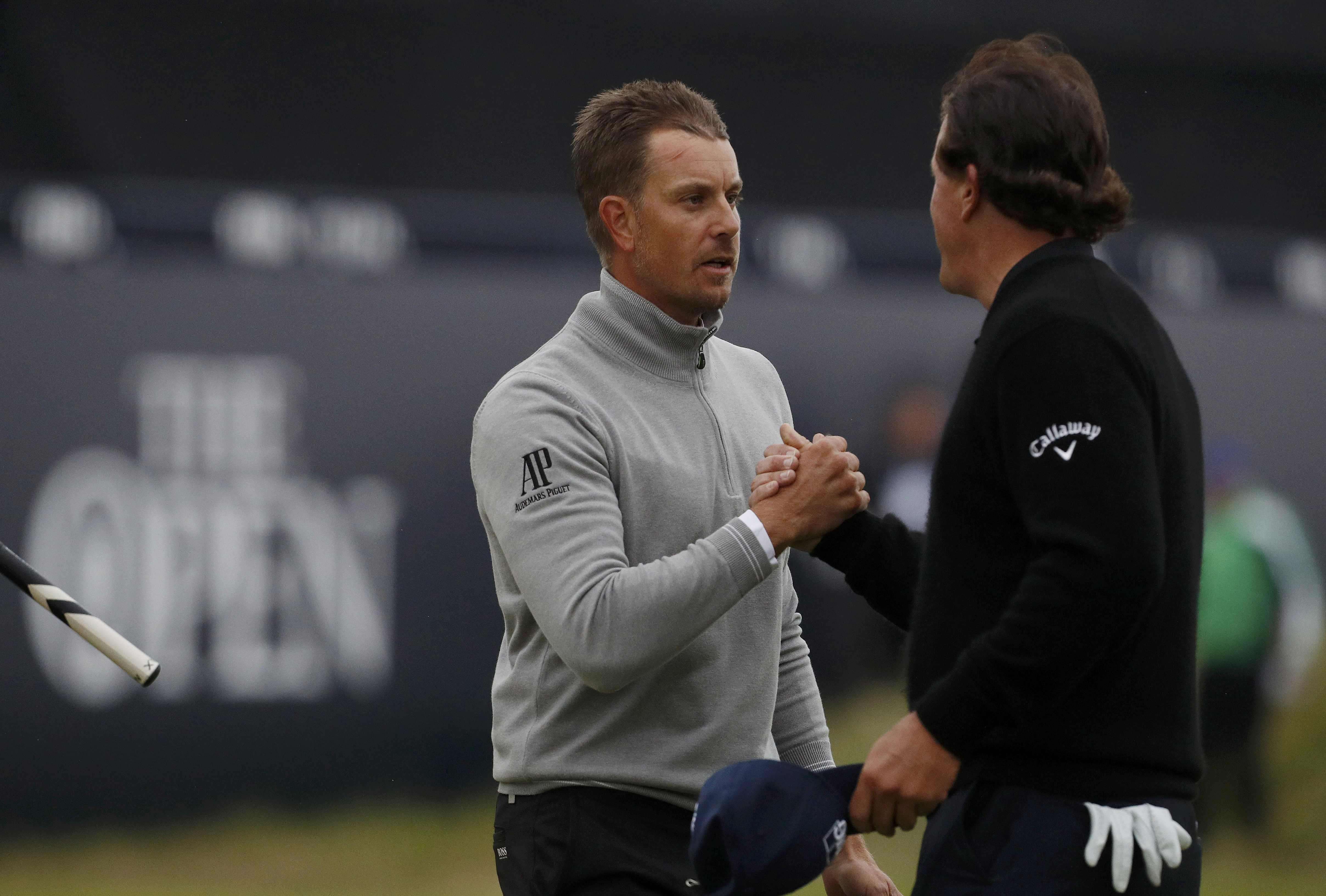 Phil Mickelson of the U.S. shakes hands with Sweden's Henrik Stenson on the 18th green during the third round. REUTERS/Craig Brough