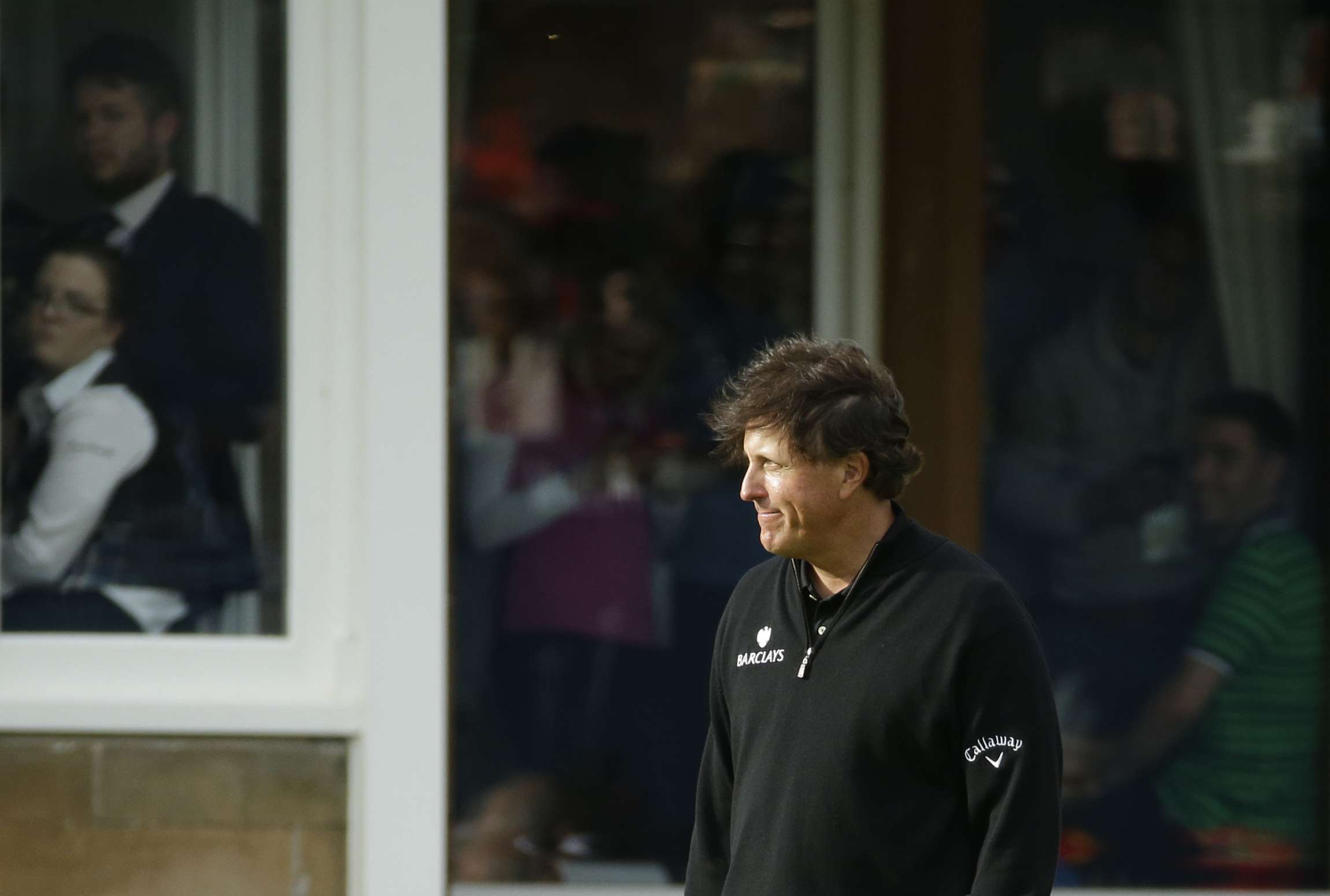 Phil Mickelson of the United States looks on as Henrik Stenson of Sweden receives the trophy. AP
