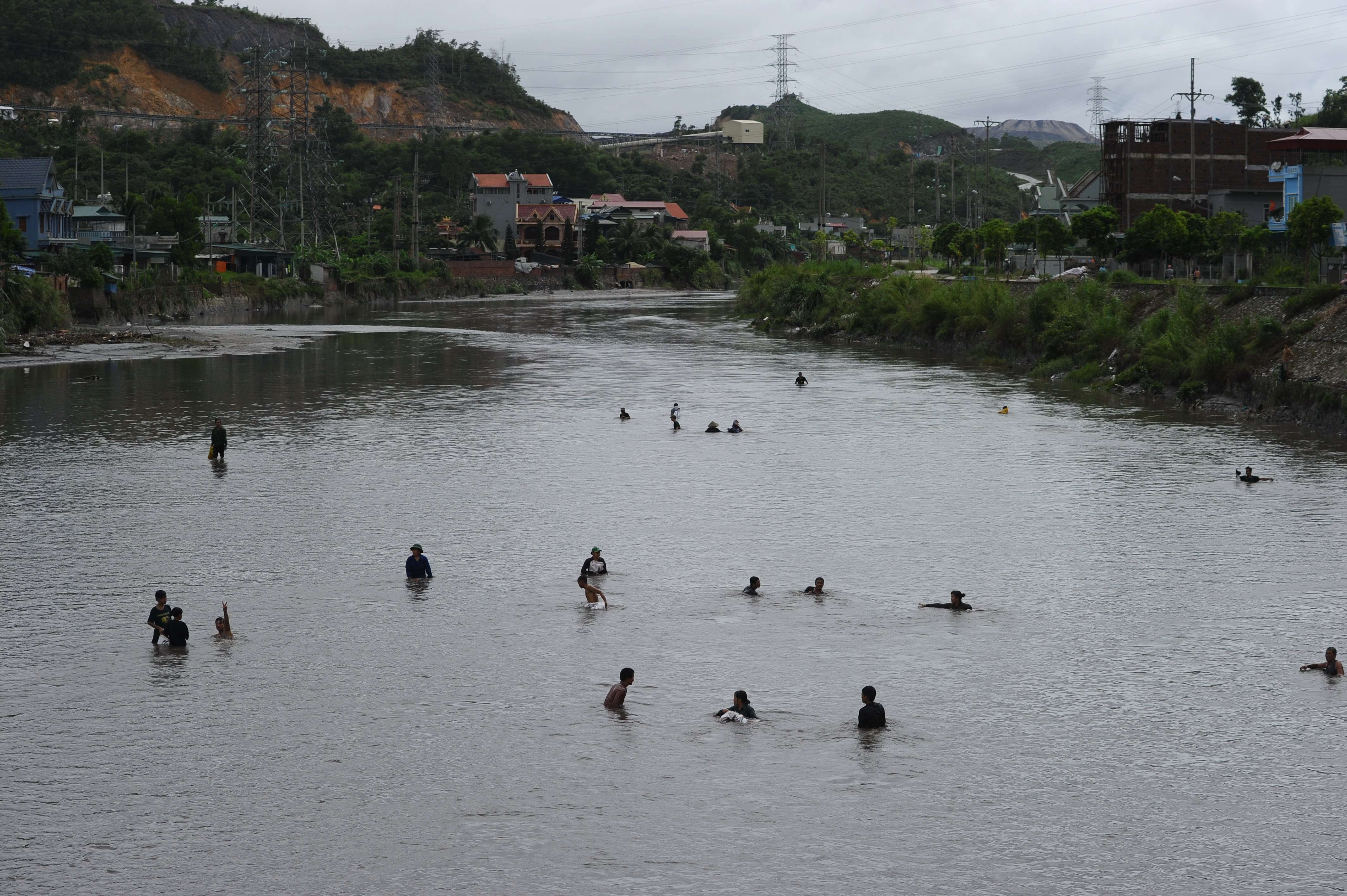 People collect coal from a flooded river next to the Mong Duong mine following heavy rains in the northern Vietnamese province of Quang Ninh, in August 2015. Picture: AFP