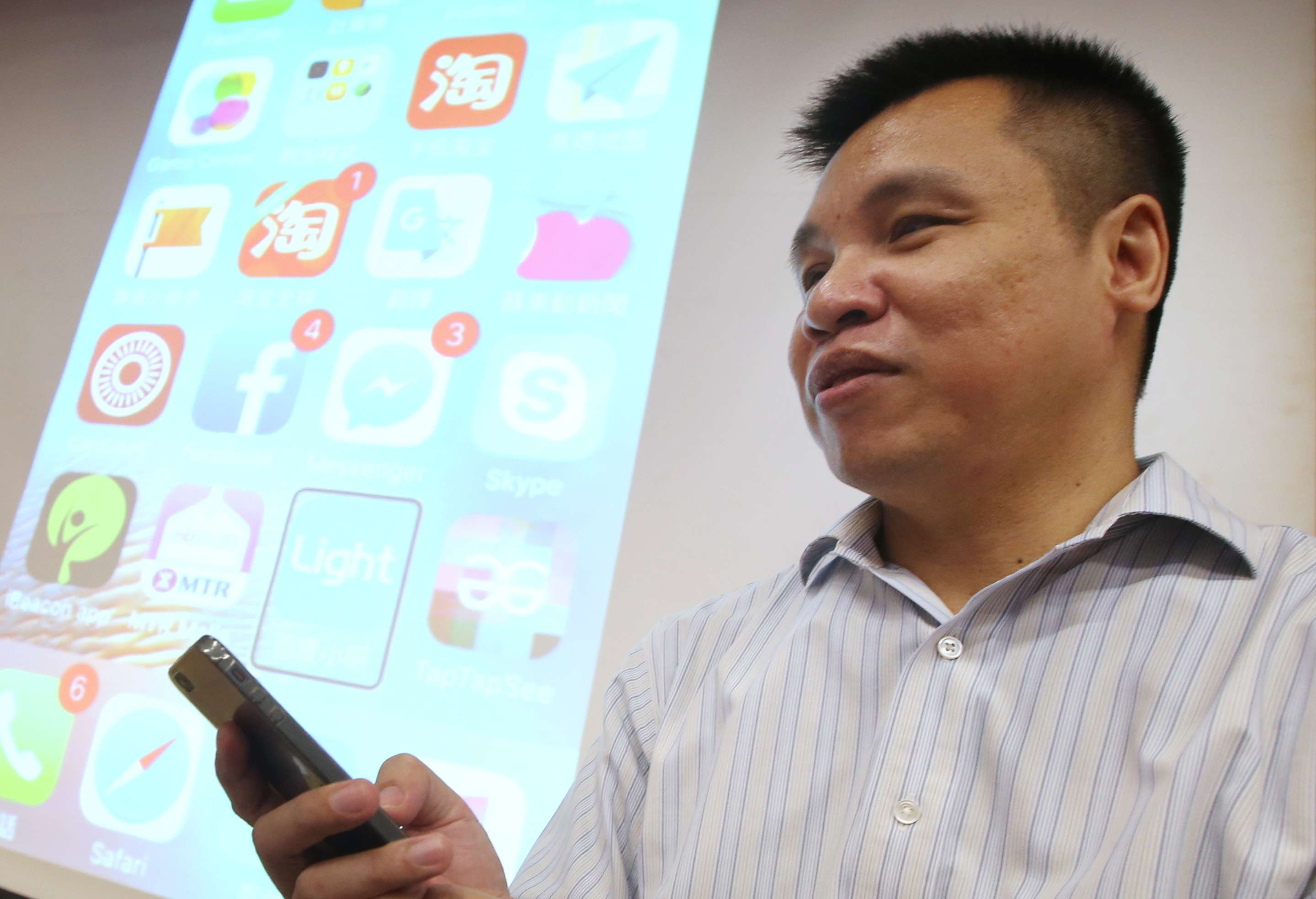 Edward Yip explains his project to collect 1,000 used iPhones for the visually impaired. Photo: David Wong