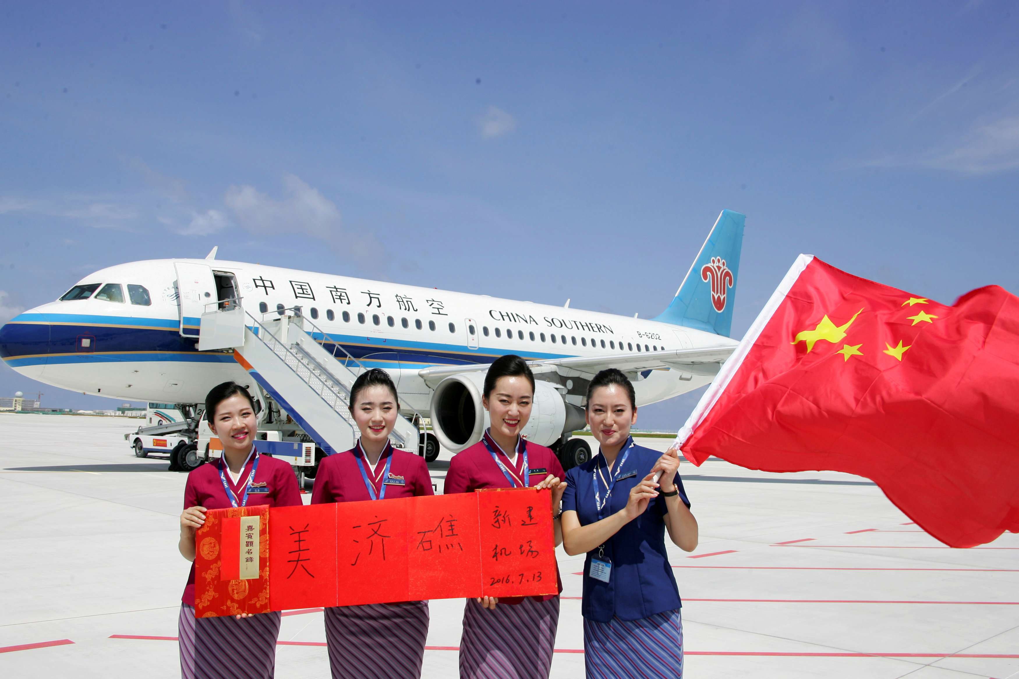 Crew members pose in front of a plane that China Southern Airlines landed at a new airport China has built on Mischief Reef in the South China Sea. Photo: Reuters
