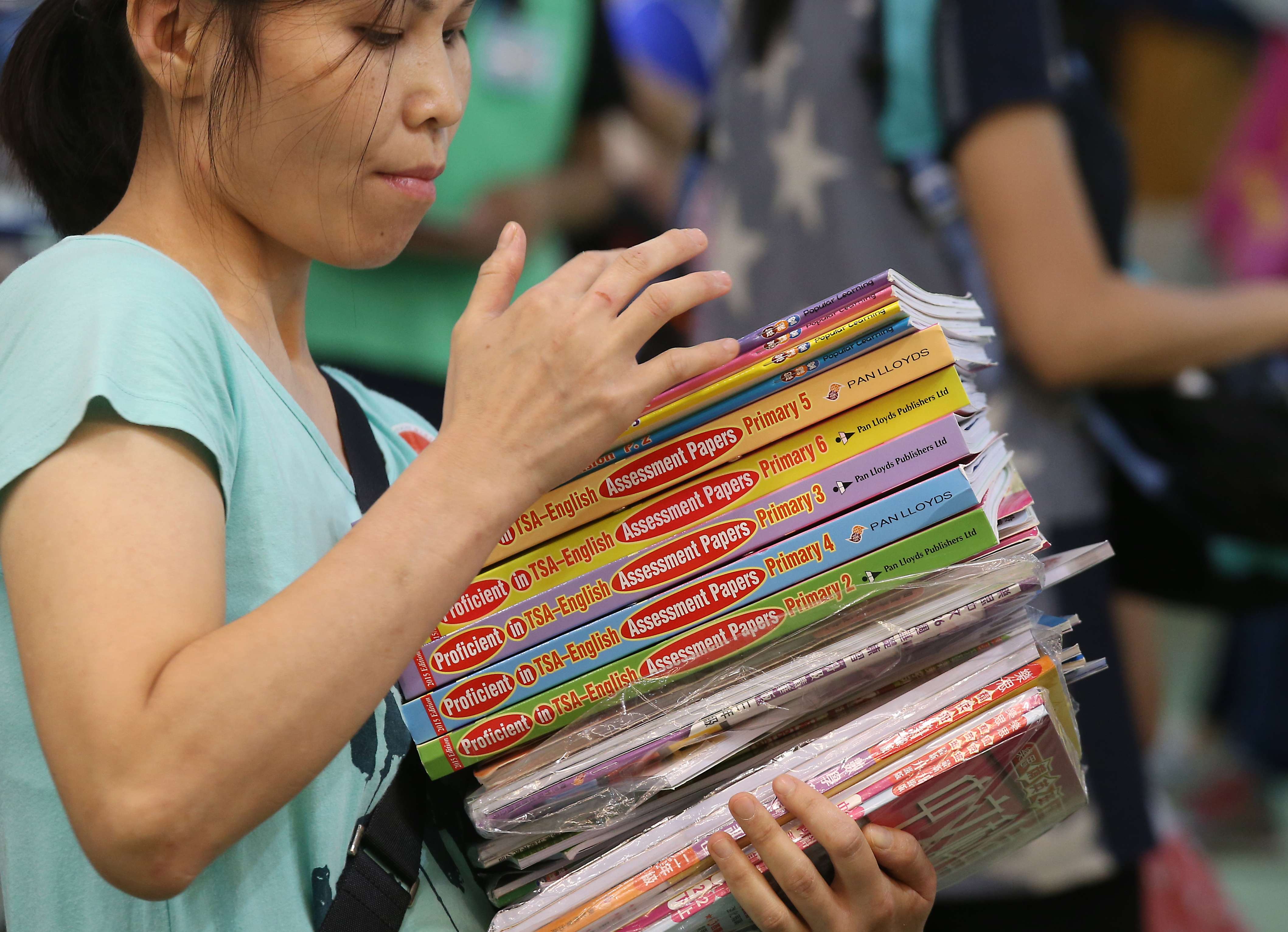 A woman holds exercise books on the first day of the 2016 Hong Kong Book Fair at the Convention and Exhibition Centre in Wan Chai. Photo: K. Y. Cheng