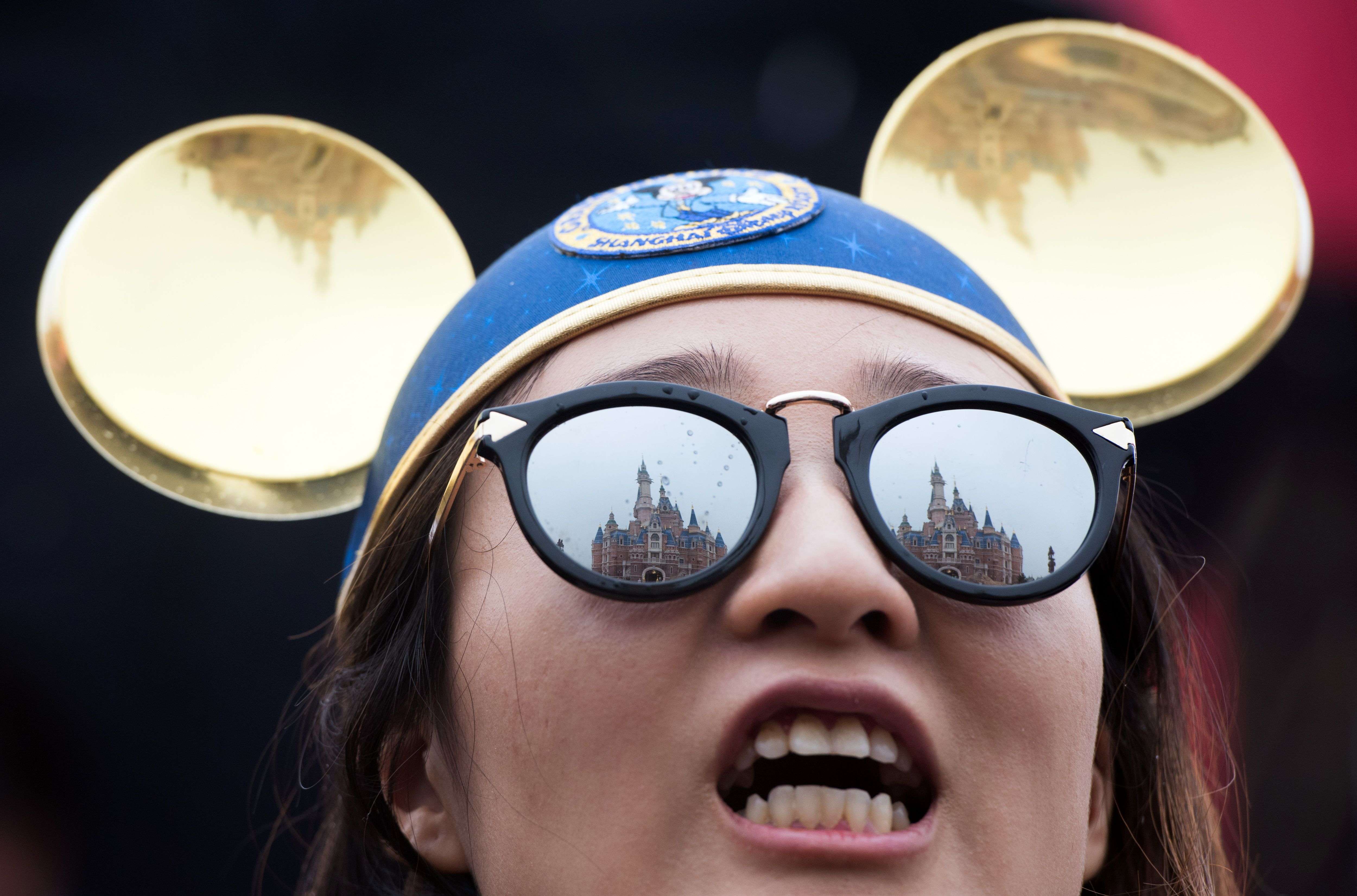 The Enchanted Storybook Castle is reflected in the sunglasses of a girl during the opening ceremony of the Shanghai Disney Resort. Photo: AFP