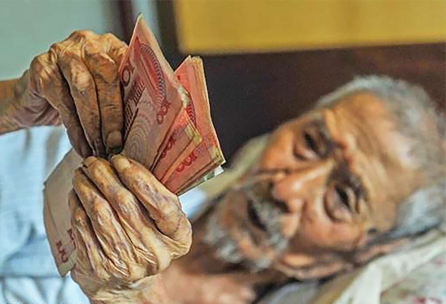 Former bank teller Lin Yongqing, 103, who spends most of his time in bed at his home in Sichuan province, still enjoys counting money every day. Photo: SCMP Pictures