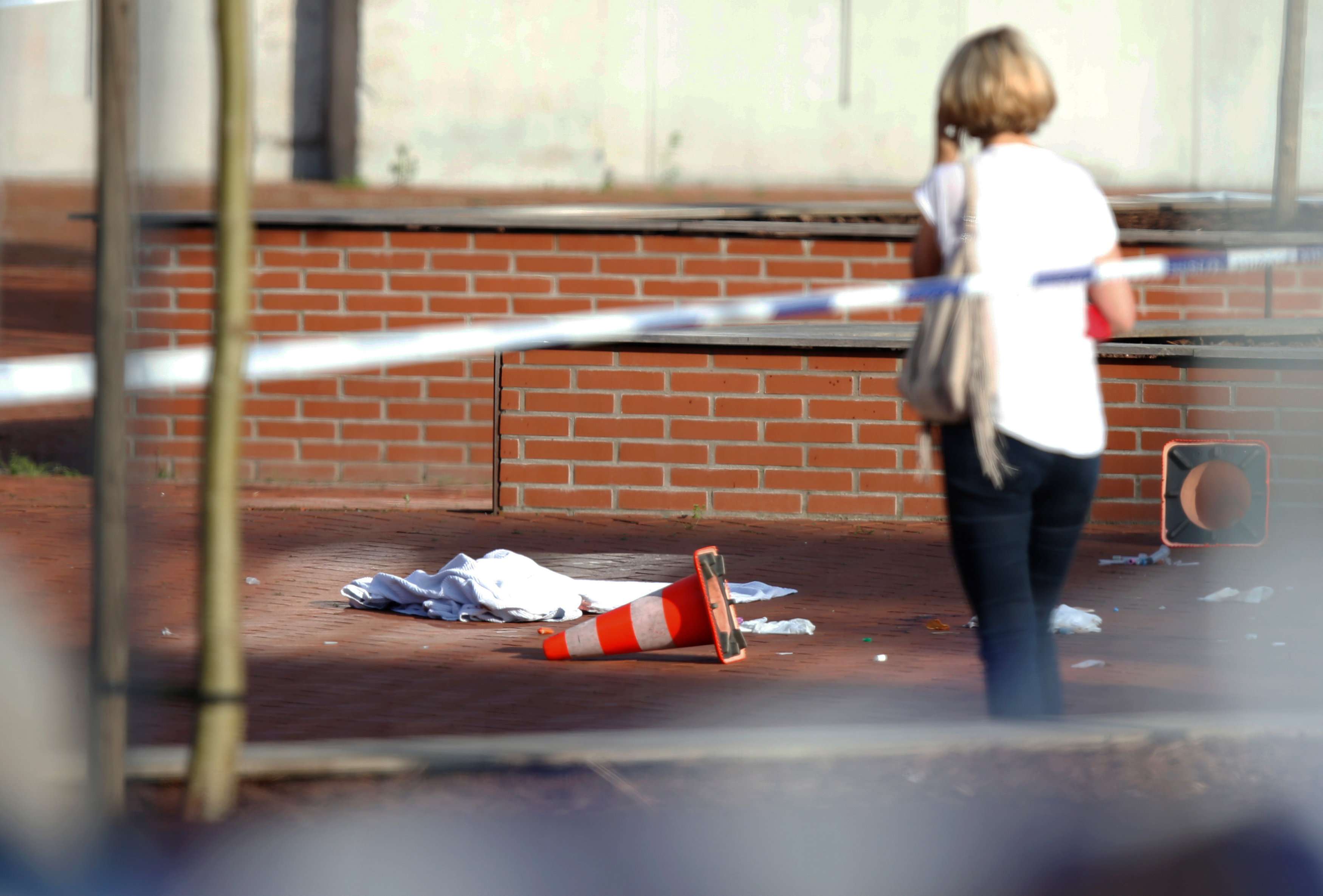 A woman stands at the site where a machete-wielding man injured two female police officers before being shot outside the main police station in Charleroi, Belgium. Photo: Reuters