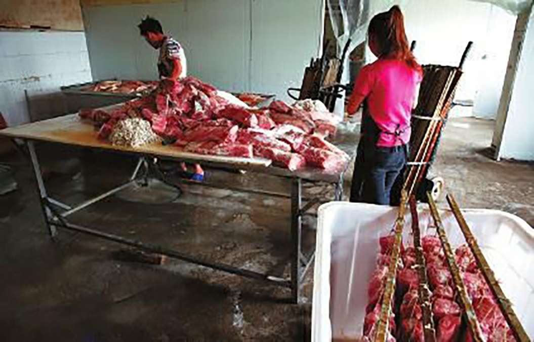 Workers prepare raw meat in the factory. SCMP Pictures (UNDATED HANDOUT)