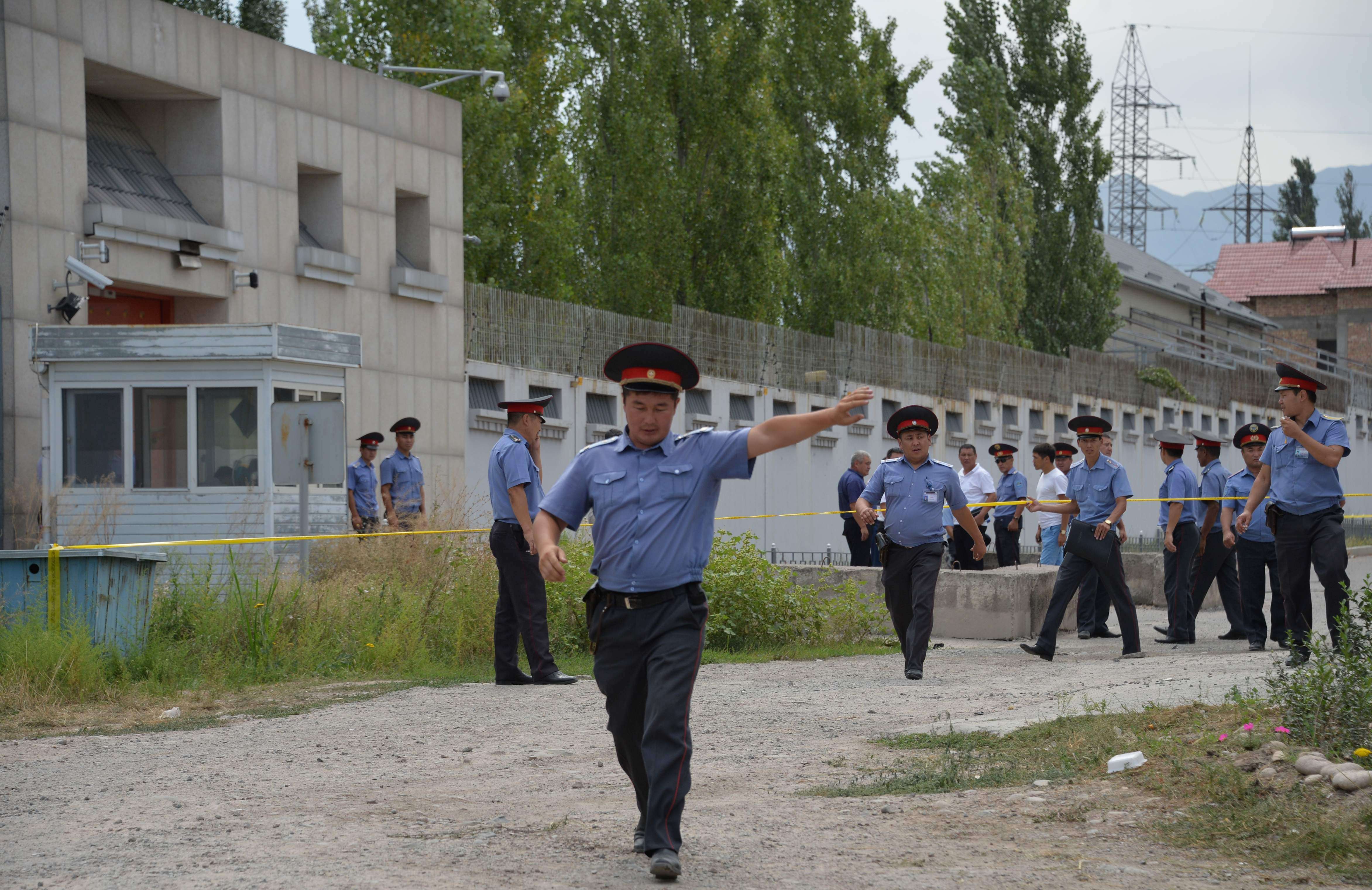Kyrgyz police officers clear the area outside the Chinese embassy in Bishkek after a suspected suicide bomber rammed his vehicle through a gate and blew himself up on August 30. Three people were wounded. Photo: AFP