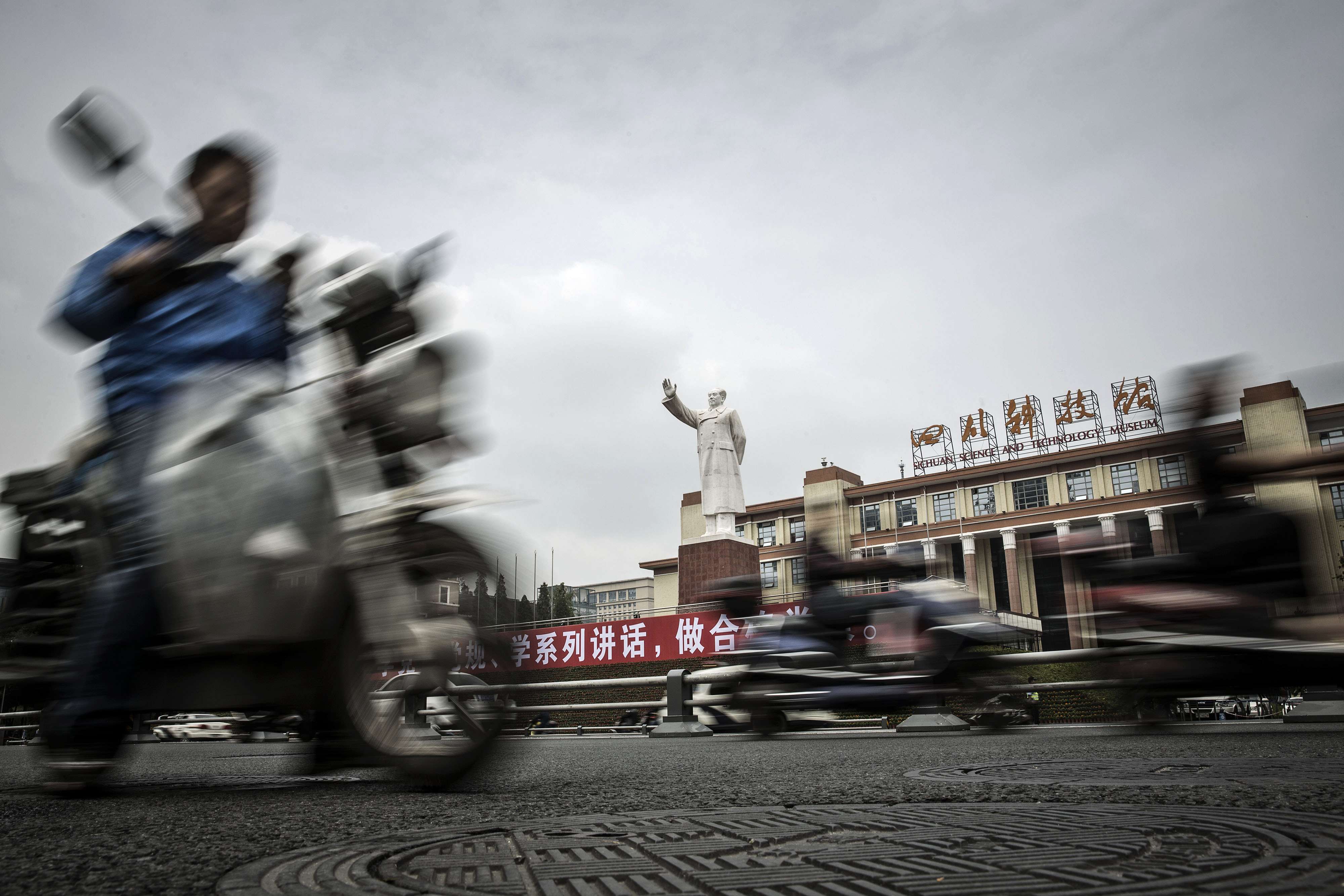 Motorcyclists ride past a statue of Mao Zedong in front of the Sichuan Science and Technology Museum in Chengdu. China’s instinctive response to pressures from net capital outflows, volatile stock markets and imbalances caused by export-led growth is more market intervention. Photo: Bloomberg