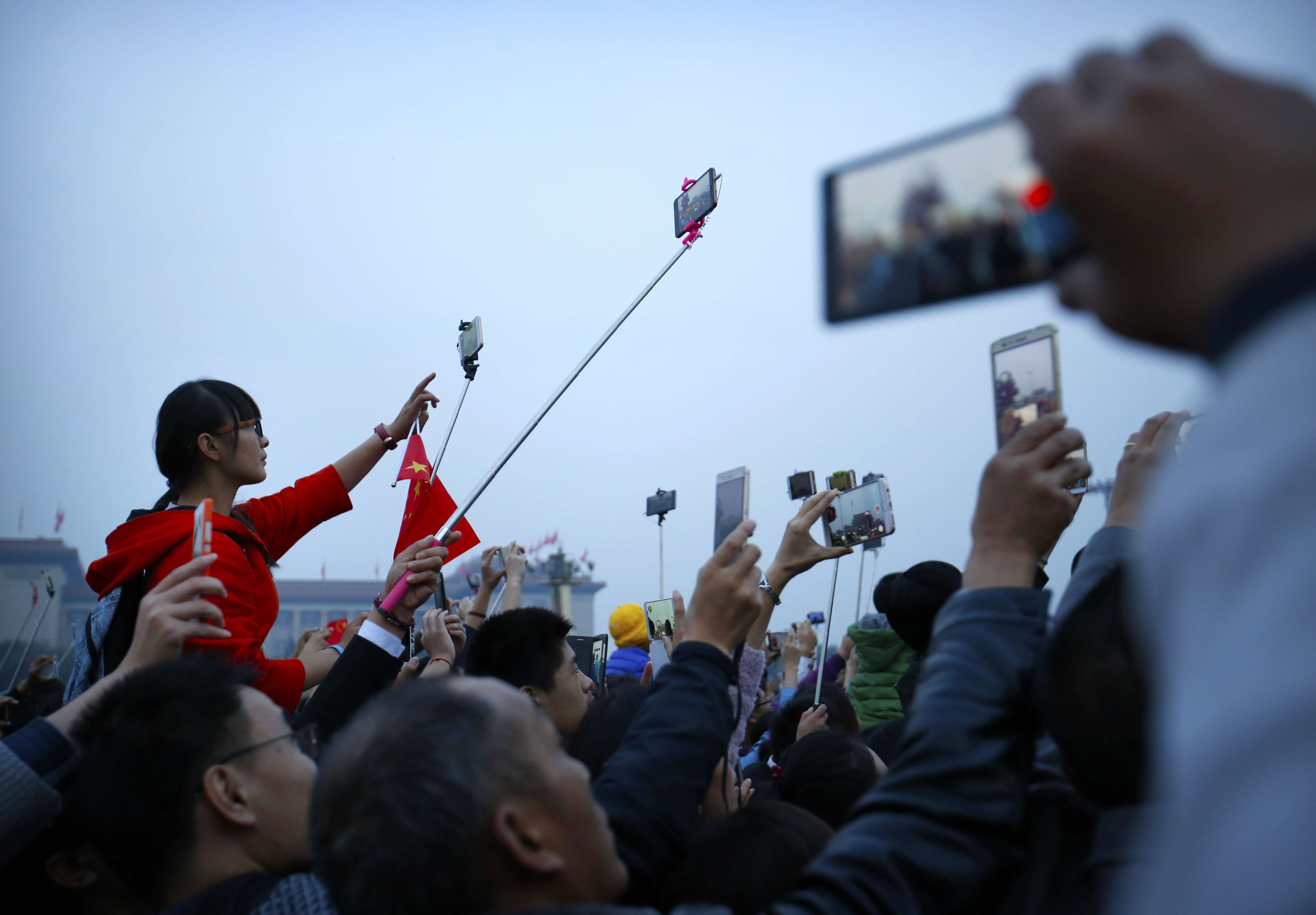 Chinese celebrating National Day on October 1 take photos of the dawn flag-raising ceremony at Tiananmen Square in Beijing. The young adults of the 21st century, along with the technological tools at their disposal, should act as a force of checks and balances in society. Photo: AP