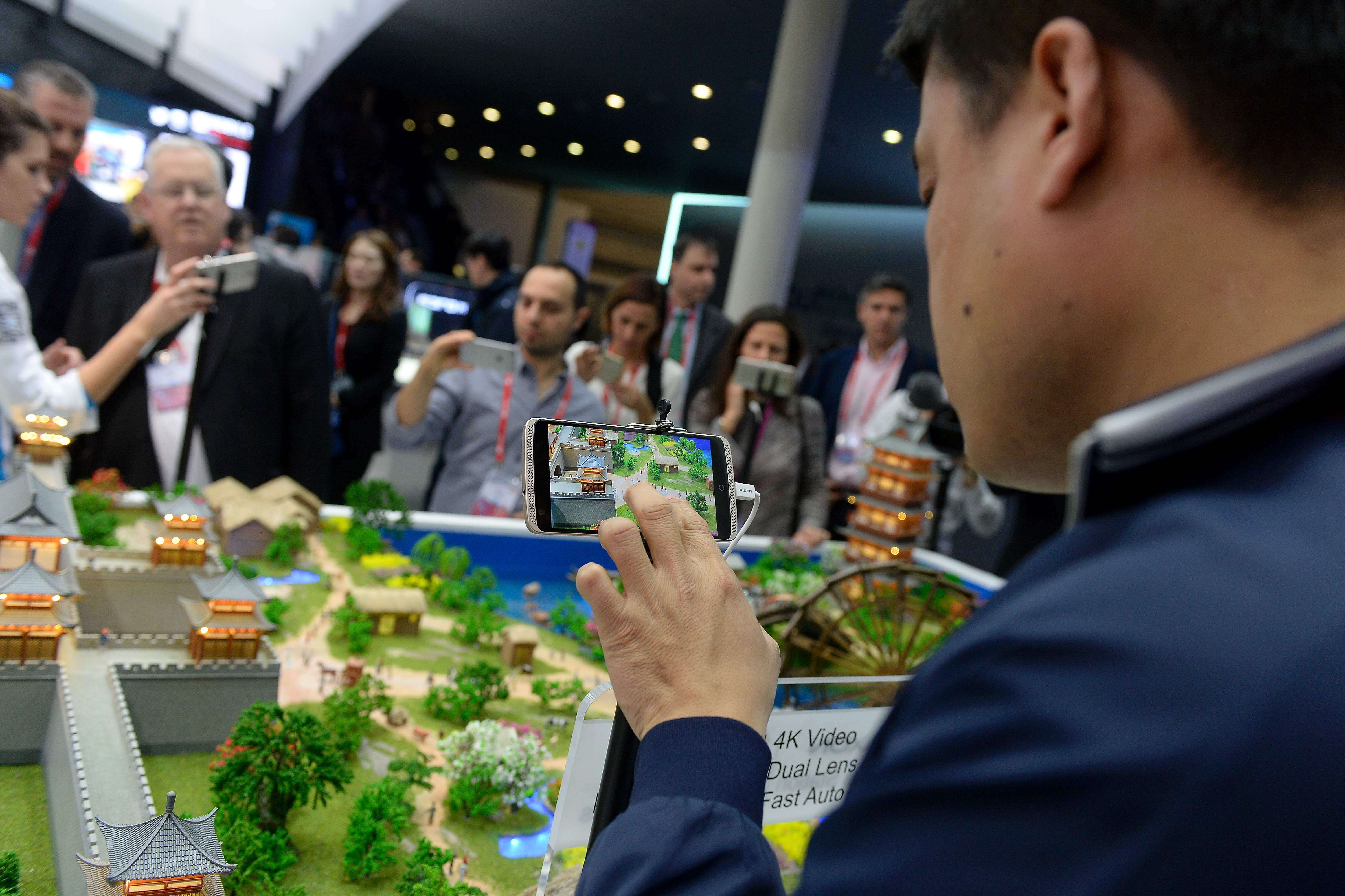 Visitors test models of the ZTE smartphones with 4K video at the Mobile World Congress in Barcelona. Photo: AFP