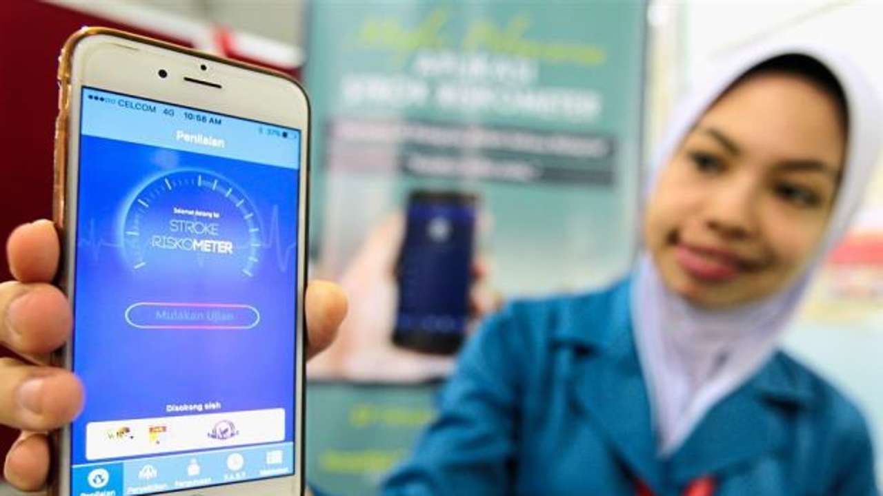 High-tech help: UKMMC staff Siti Munirah Ismail showing the ‘Stroke Riskometer’ smartphone app. Photo: The Star