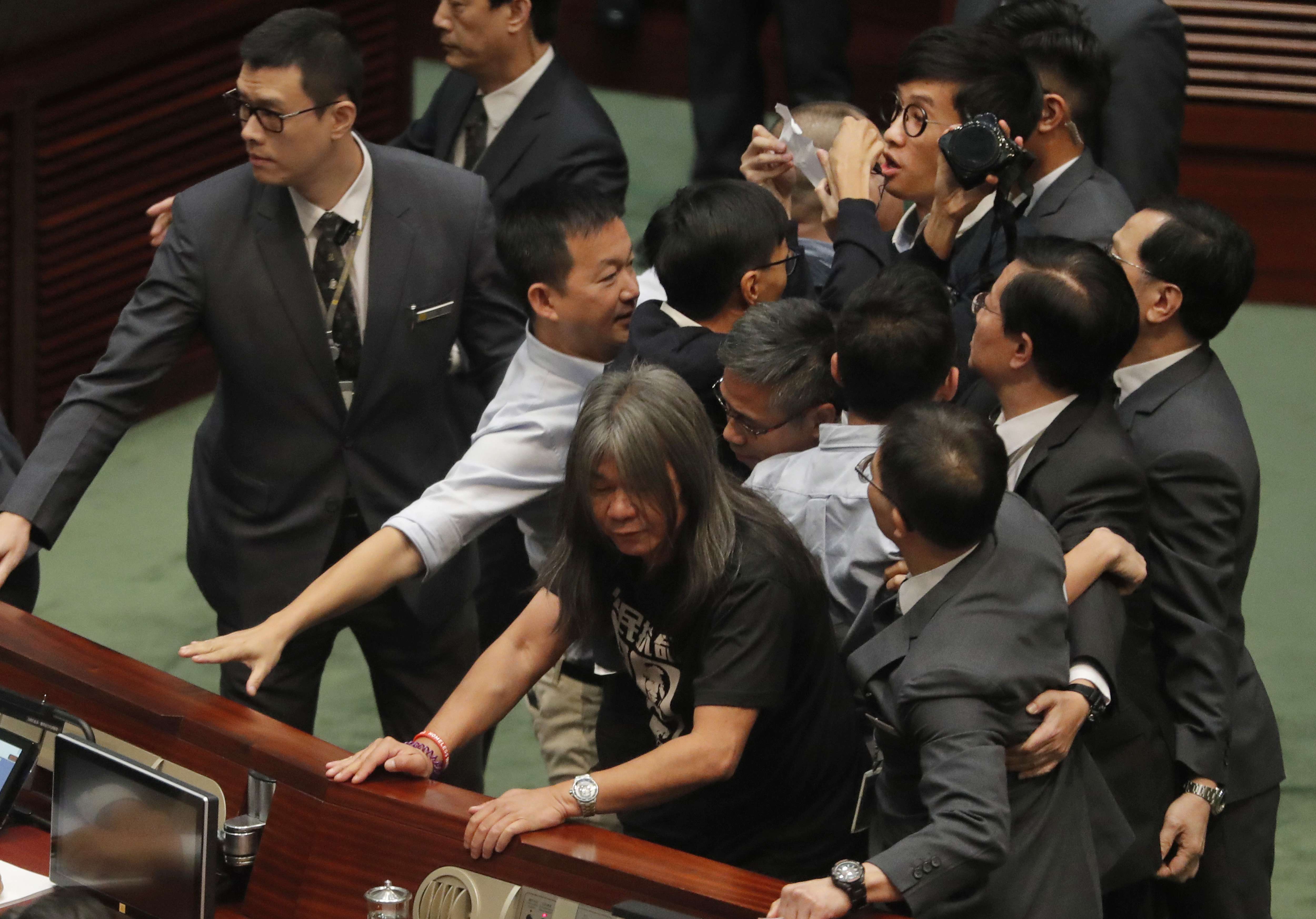 Pan-democrats join the scrum amid scuffles with Legislative Council security guards as they try to prevent Sixtus Leung (centre, holding a piece of paper) from retaking his oath on November 2. Photo: AP