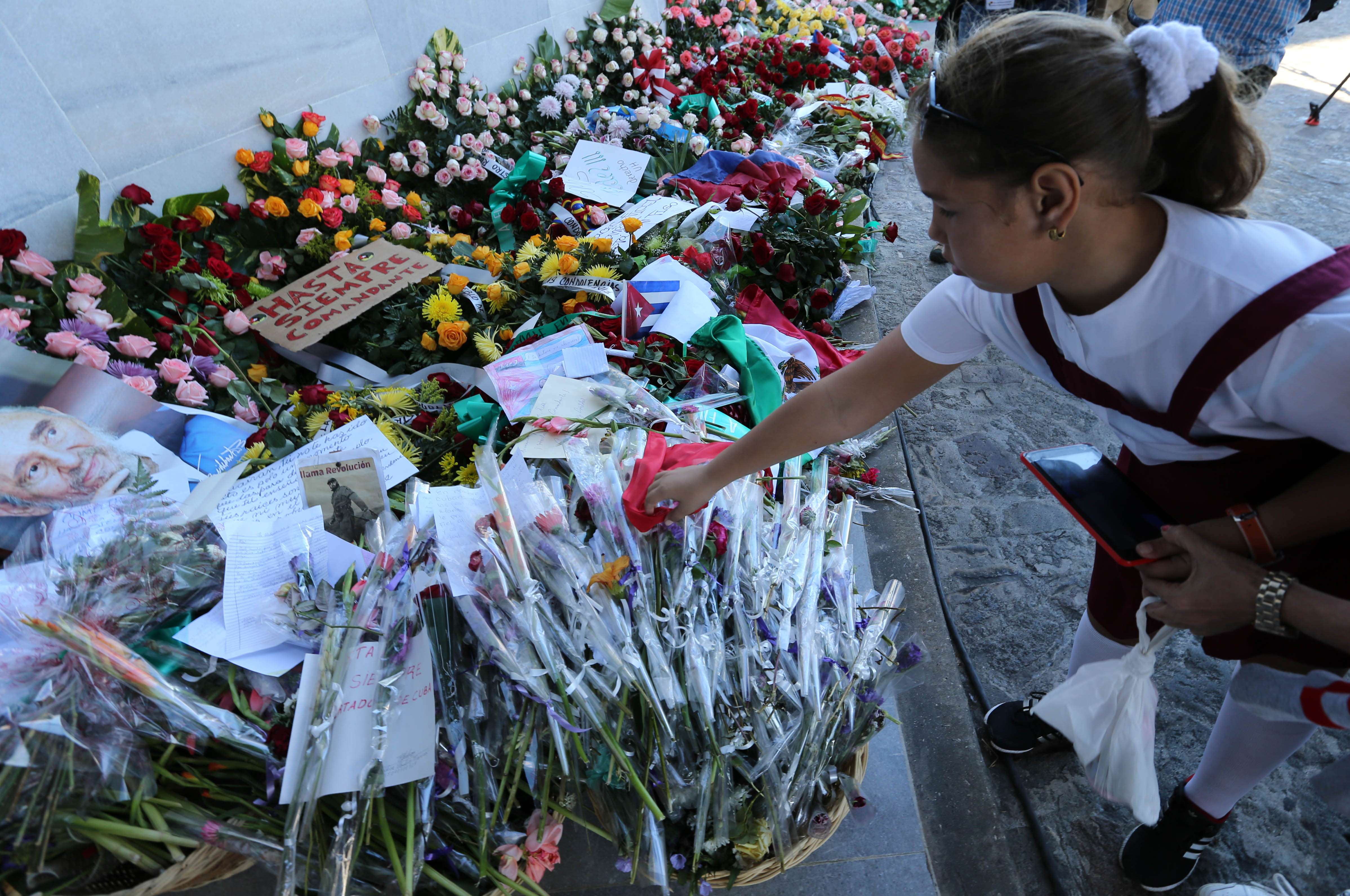 A girl lays flowers to pay tribute to Cuban revolutionary leader Fidel Castro. Photo: Xinhua