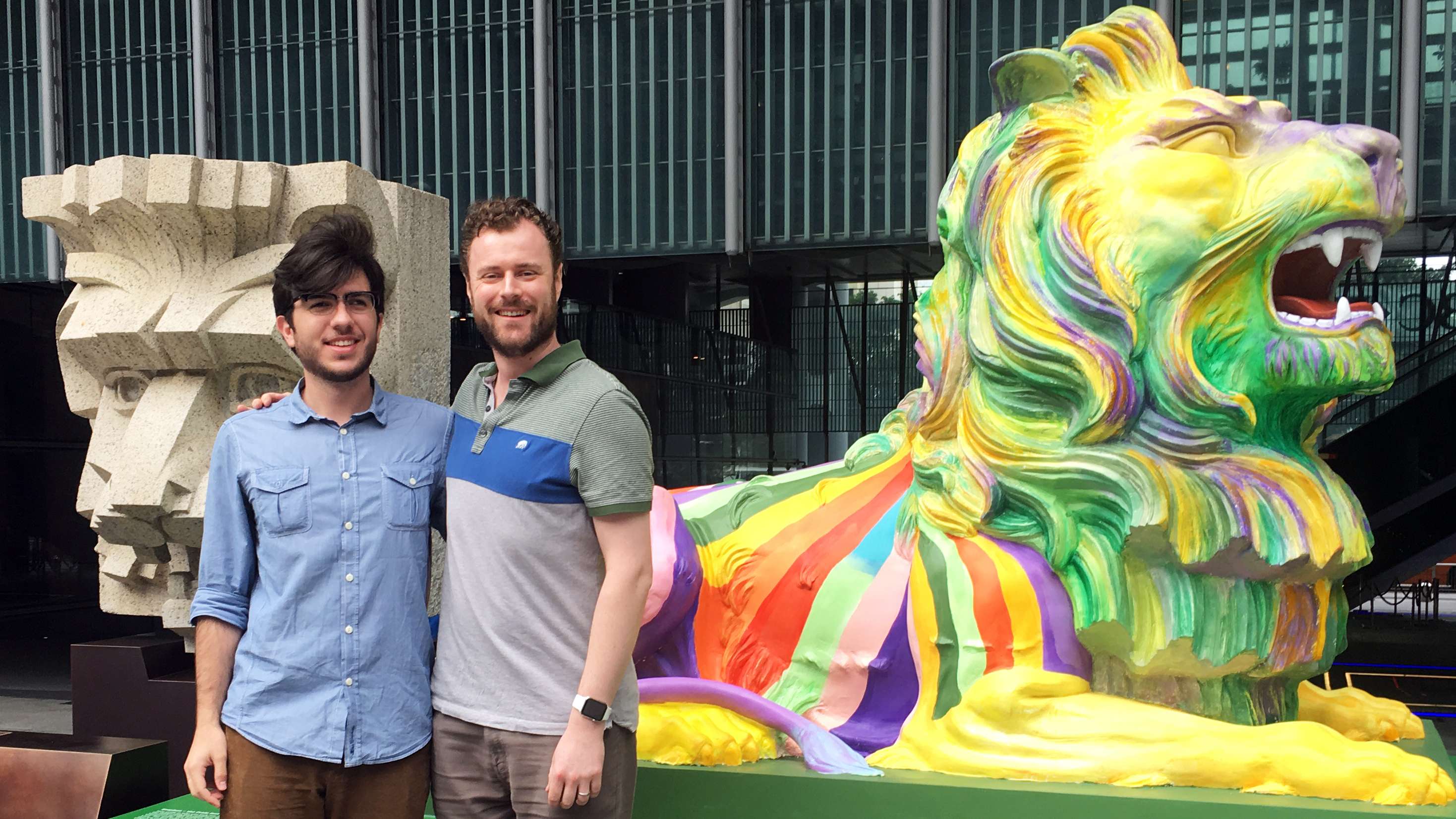 Pedro Lino (left) from Brazil poses with his partner, Adam Dolman of the UK, in front of one of the rainbow lions celebrating “pride and unity” at the HSBC headquarters in Central on December 14. Photo: Kinling Lo
