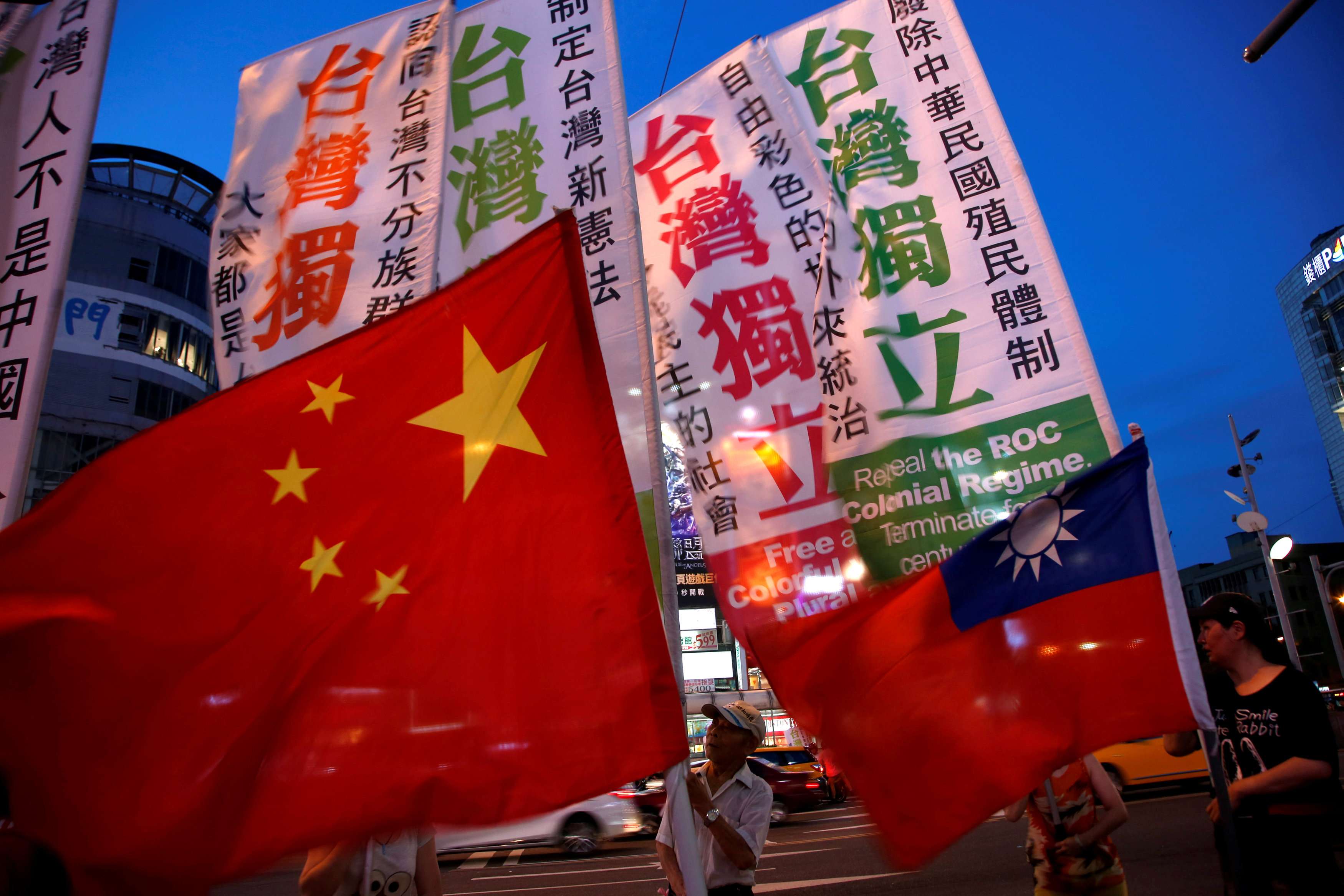 Members of a pro-independence group march with flags of Taiwan around pro-China demonstrators holding a rally calling for peaceful reunification, in Taipei on May 14. Photo: Reuters