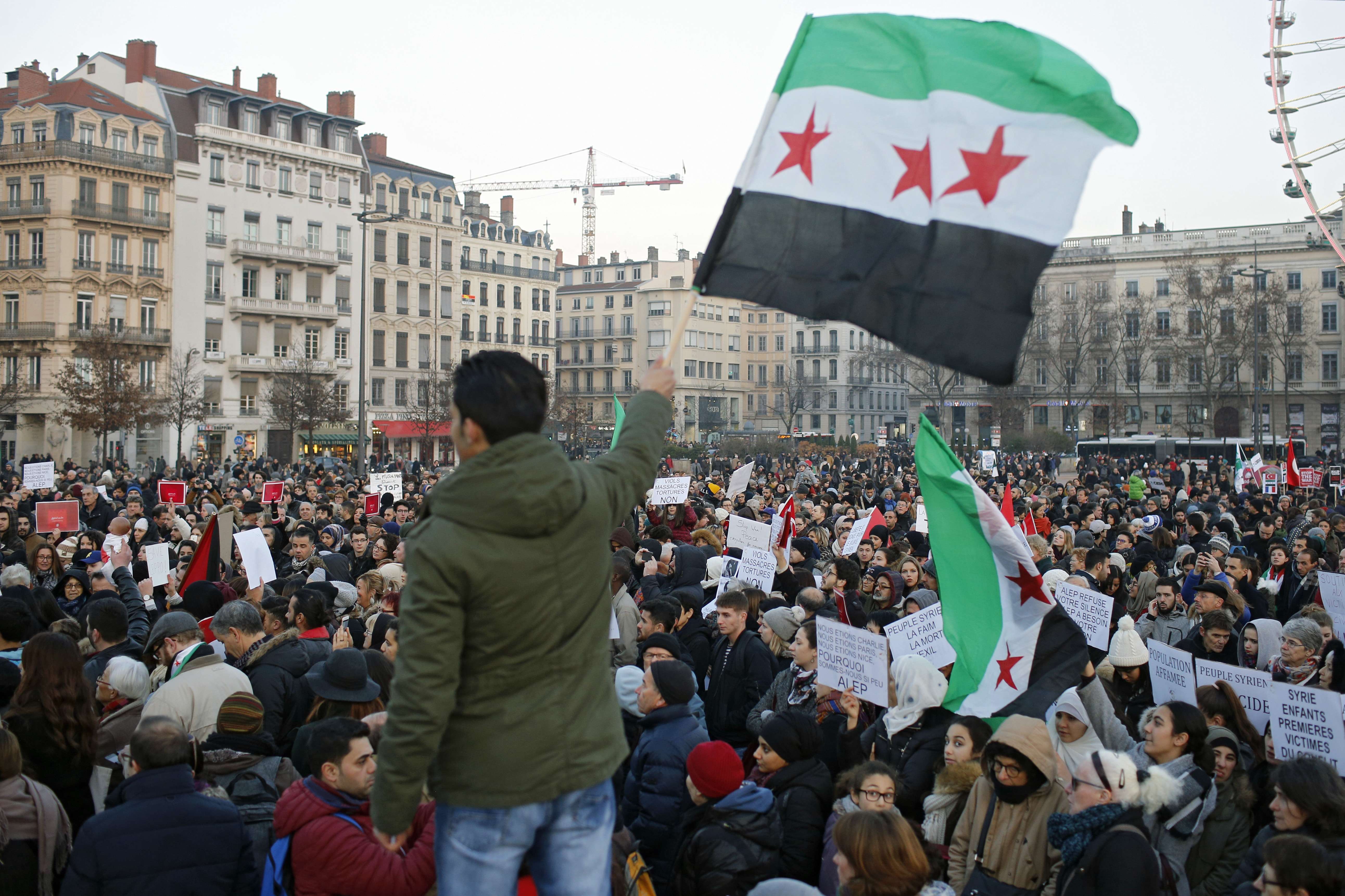 Demonstrators in Lyon, France, wave Syrian flags as they protest against the war and the humanitarian crisis in Aleppo, on December 17. Photo: AP