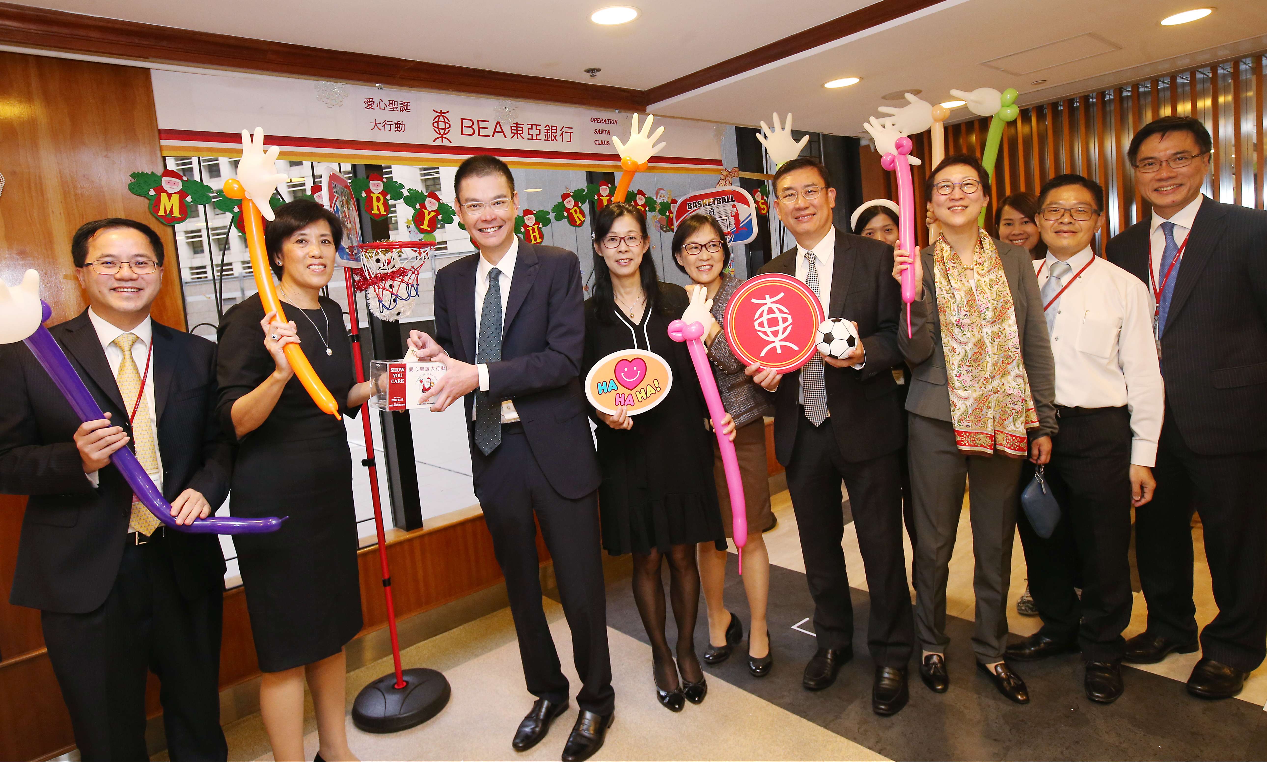 Executive director Adrian Li (third from left), general manager and head of HR Mimi Kam (second left) and other Bank of East Asia staff raise a cheer after a week of charity events. Photos: David Wong