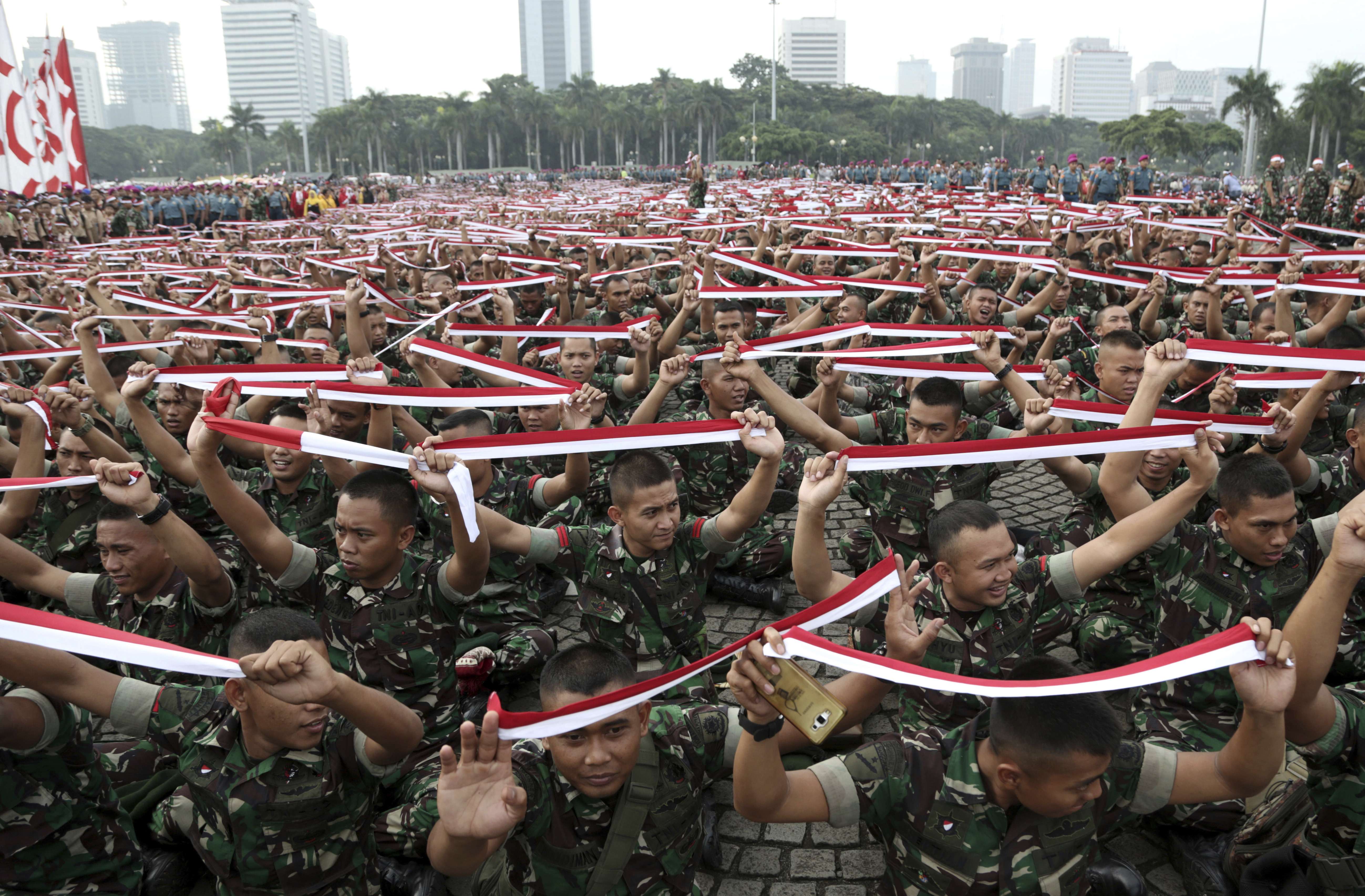 Indonesian soldiers hold up headbands in the colour of the national Red-White flag during a military-sponsored interfaith rally held ahead of a Muslim rally against Jakarta Governor Basuki Tjahaja Purnama. Photo: AP