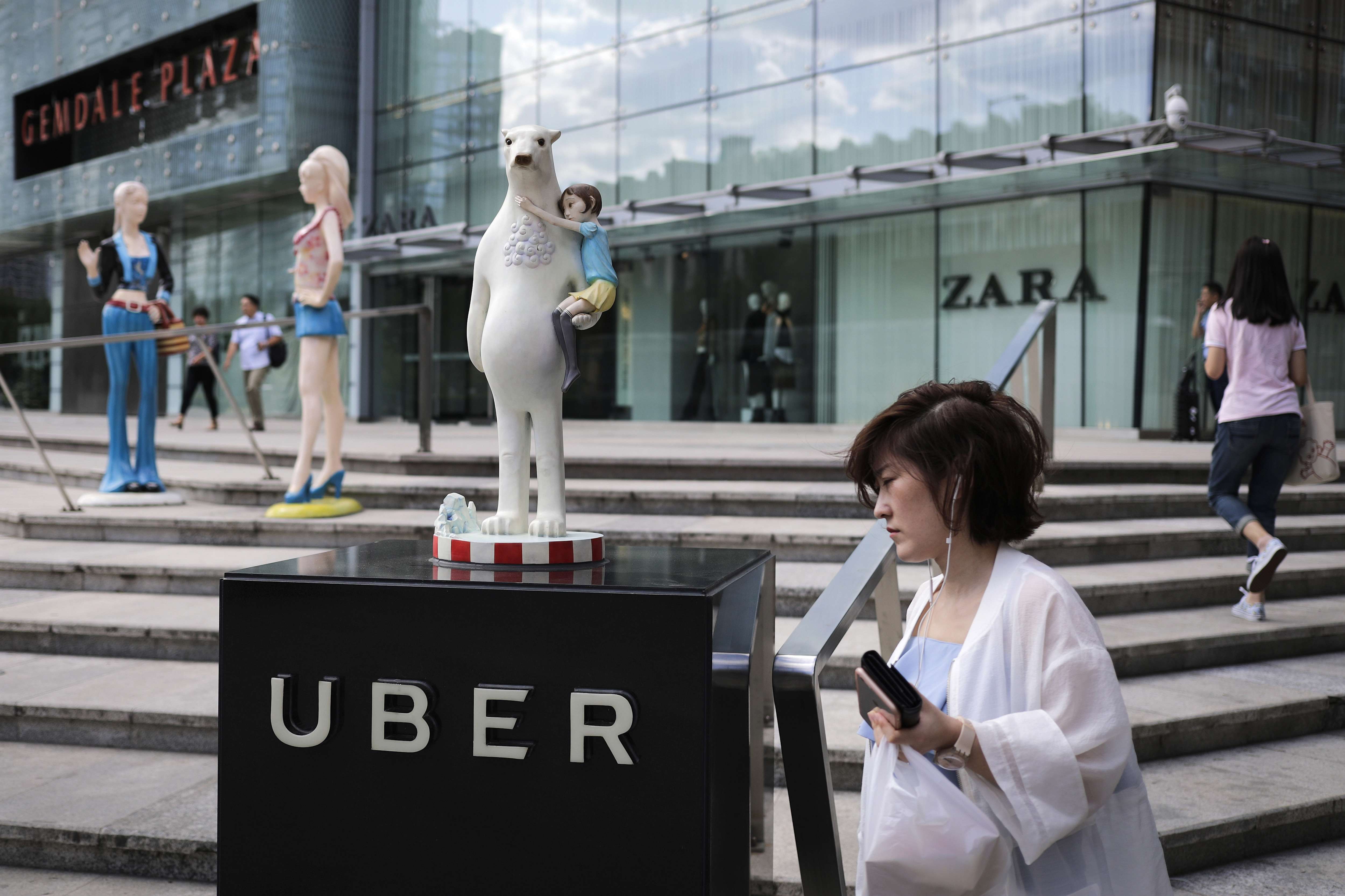 A woman walks past an Uber station outside a shopping mall in Beijing. Photo: AP