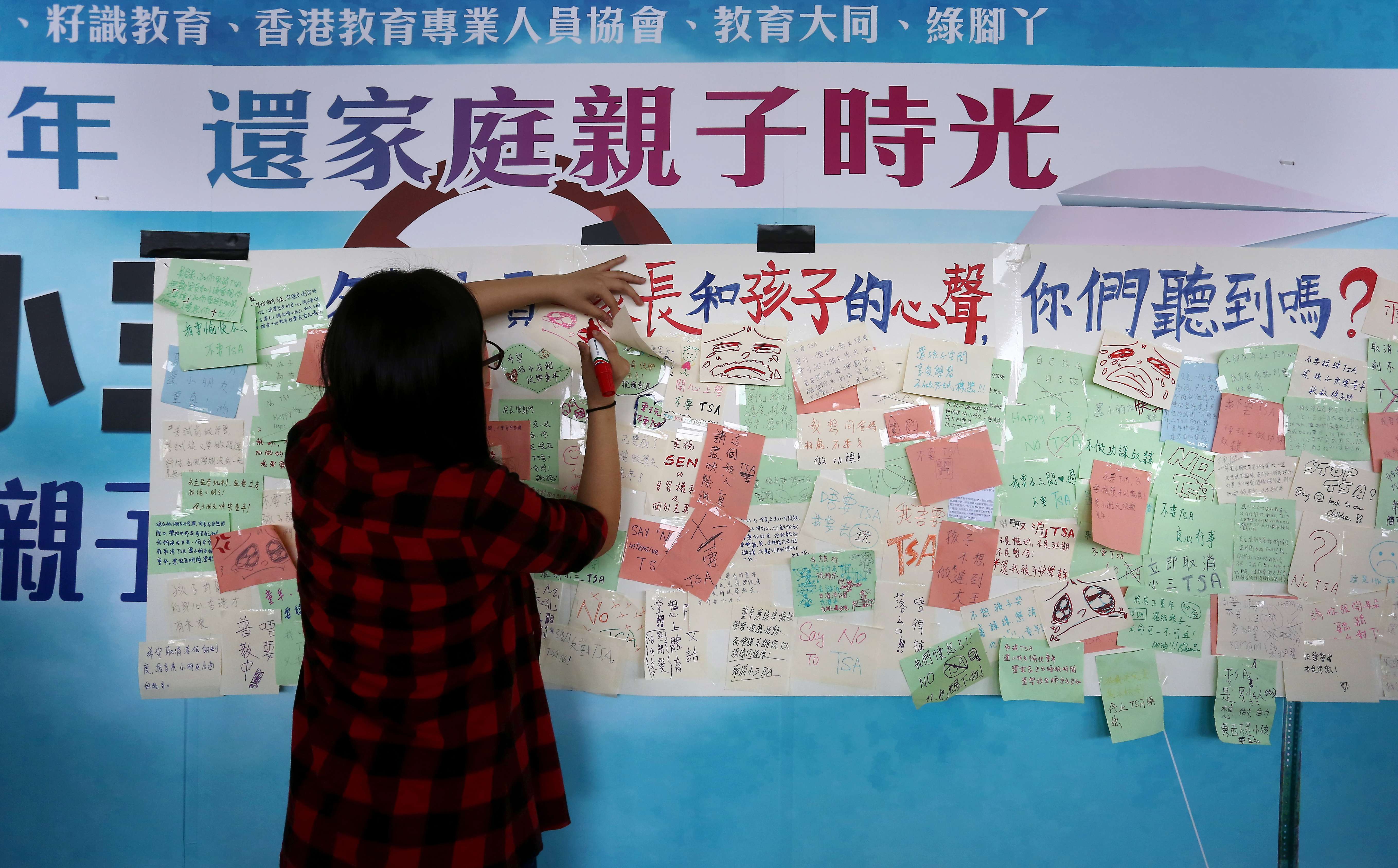 A woman writes on a message board put up by activists protesting against the TSA, outside the Legislative Council building in Tamar, in November 2015. Photo: Jonathan Wong