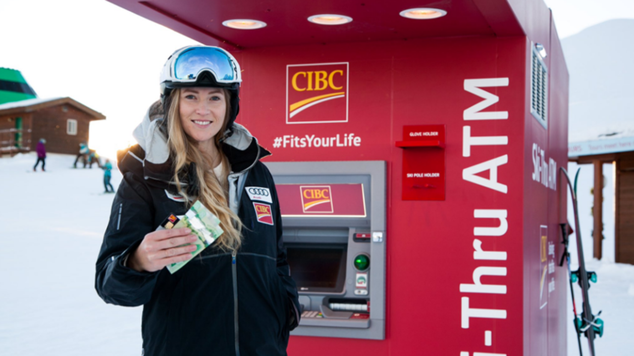 Ashleigh DeMerit uses the new CIBC ATM atop Whistler Mountain. DeMerit won a gold medal at the 2010 Winter Olympics in ski cross when she was known as Ashleigh McIvor. She has since married former Vancouver Whitecap Jay DeMerit. Photo: CIBC