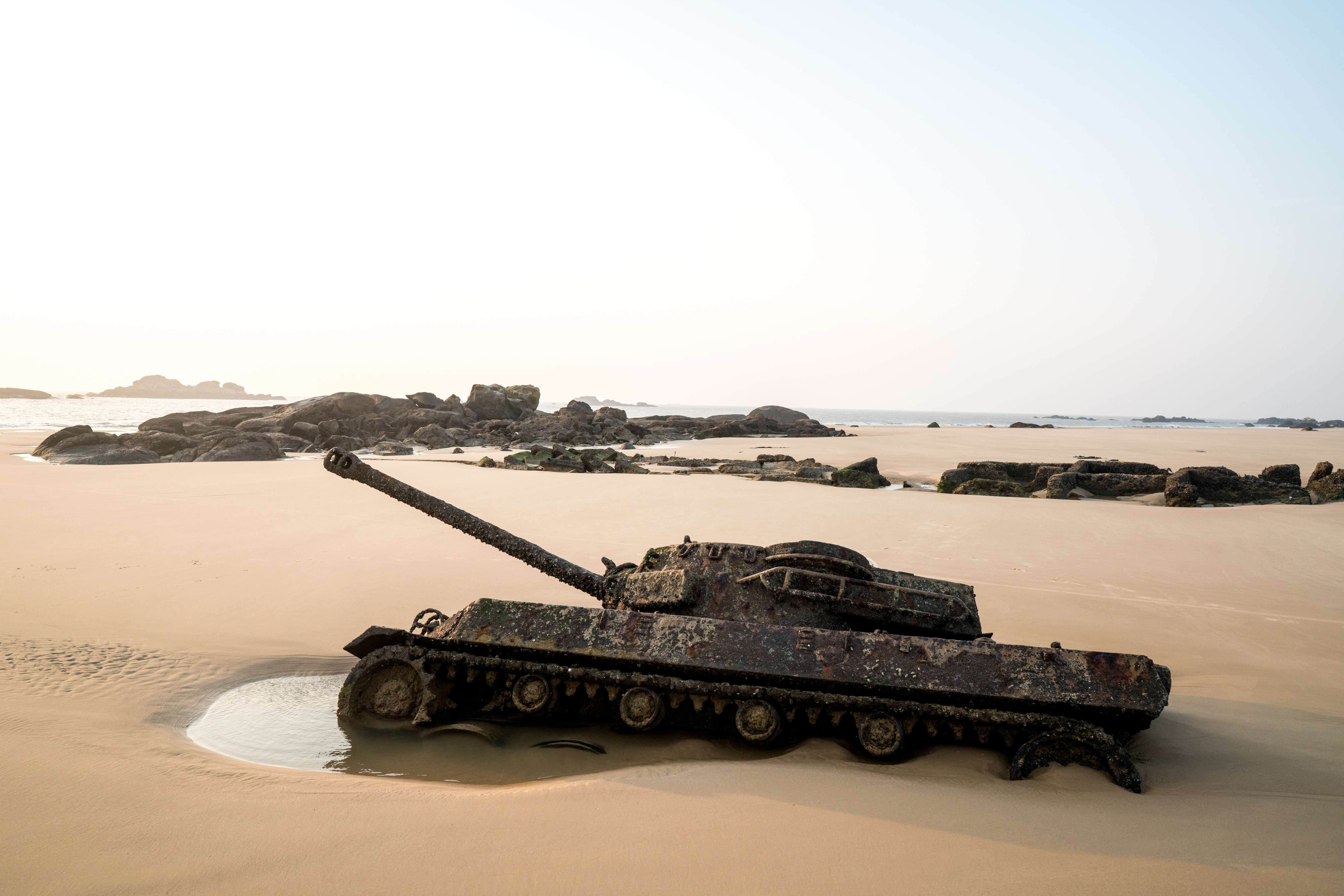 A tank half buried in the sand on a beach in Kinmen emerges from the ground at low tide. Photo: Sim Chi Yin / VII