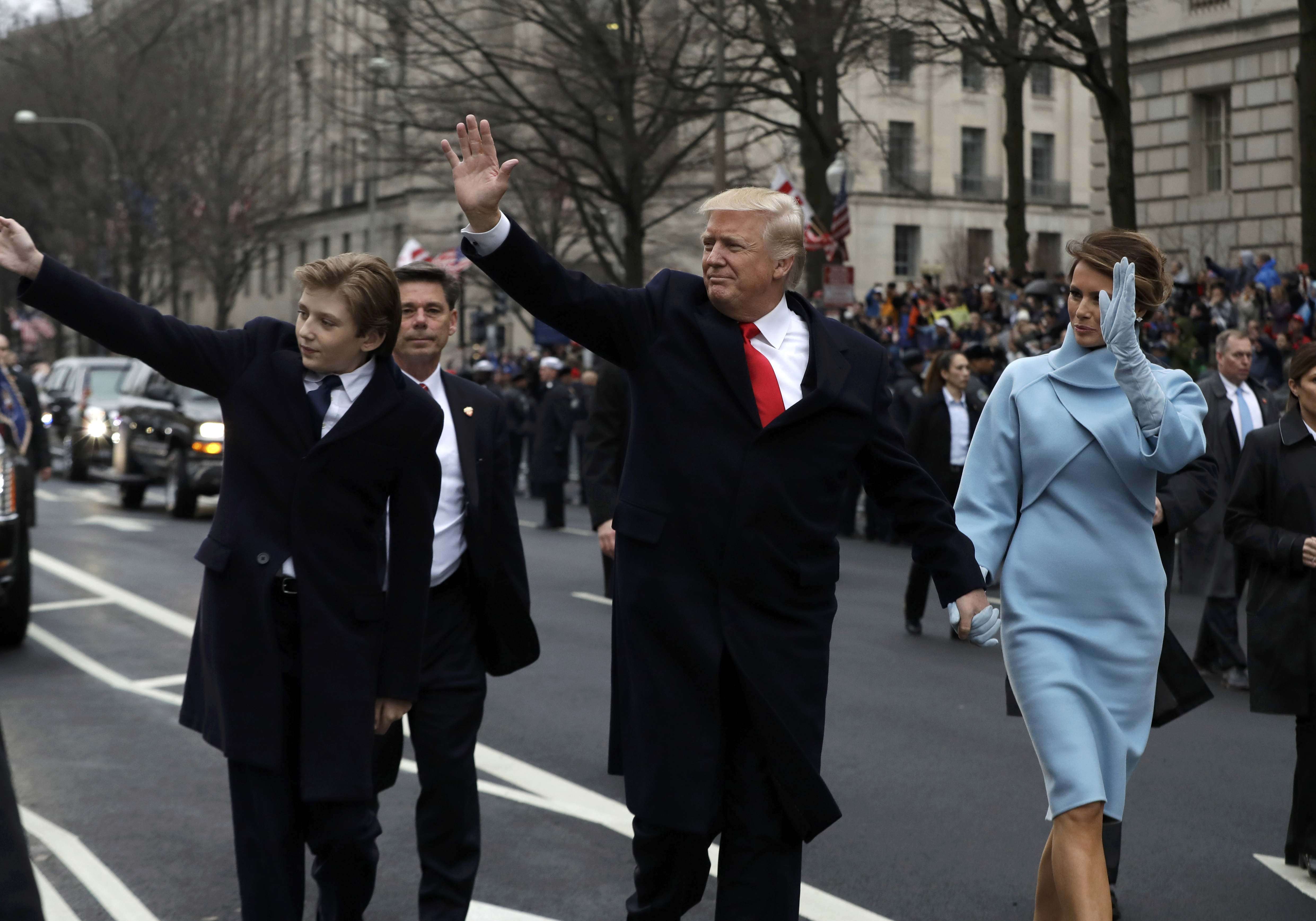 US President Donald Trump waves as he walks with first lady Melania Trump and their son Barron, left, during the inauguration parade on Pennsylvania Avenue in Washington DC. Photo: Reuters