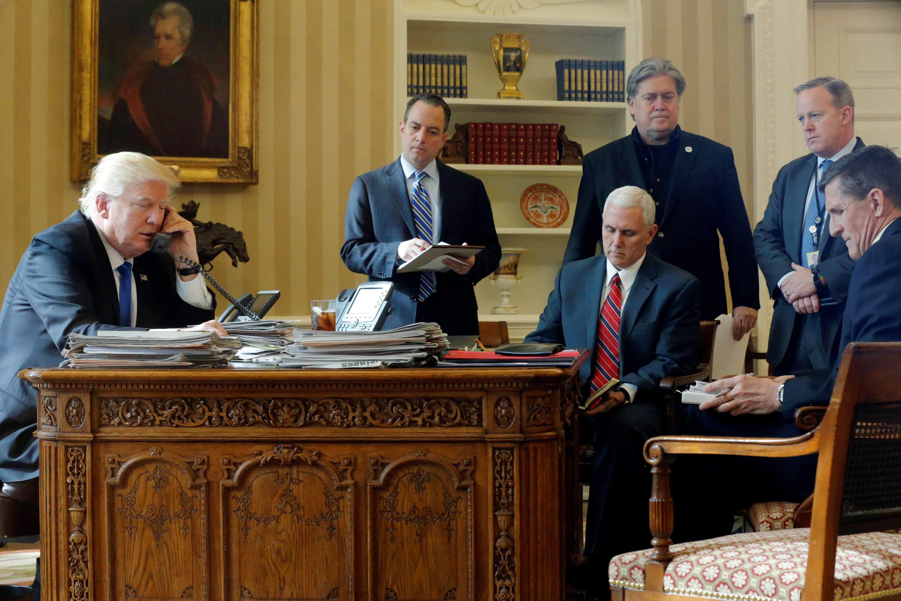 US President Donald Trump speaks on the phone with Russian President Vladimir Putin in the Oval Office, watched by his White House inner circle (left to right), Chief of Staff Reince Priebus, Vice-President Mike Pence, Chief Strategist Steve Bannon, Communications Director Sean Spicer and National Security Adviser Michael Flynn, on January 28. Photo: Reuters