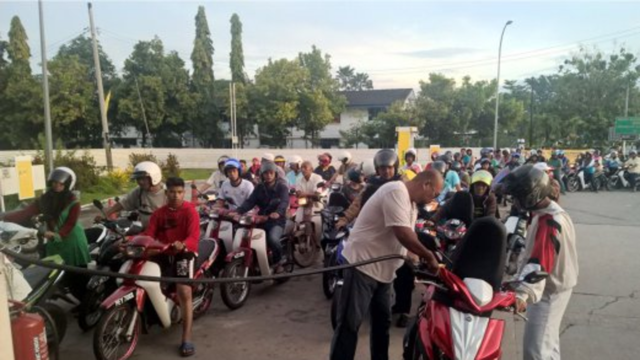 Motorists seen flocking to a petrol station in Sungai Petani, Malaysia. Local philanthropist Abdul Ghani Haron, who shot to fame for a series of incredible charitable acts, struck again today by giving away free petrol fill-ups to motorcyclists here this morning. Photo: Omar Osman