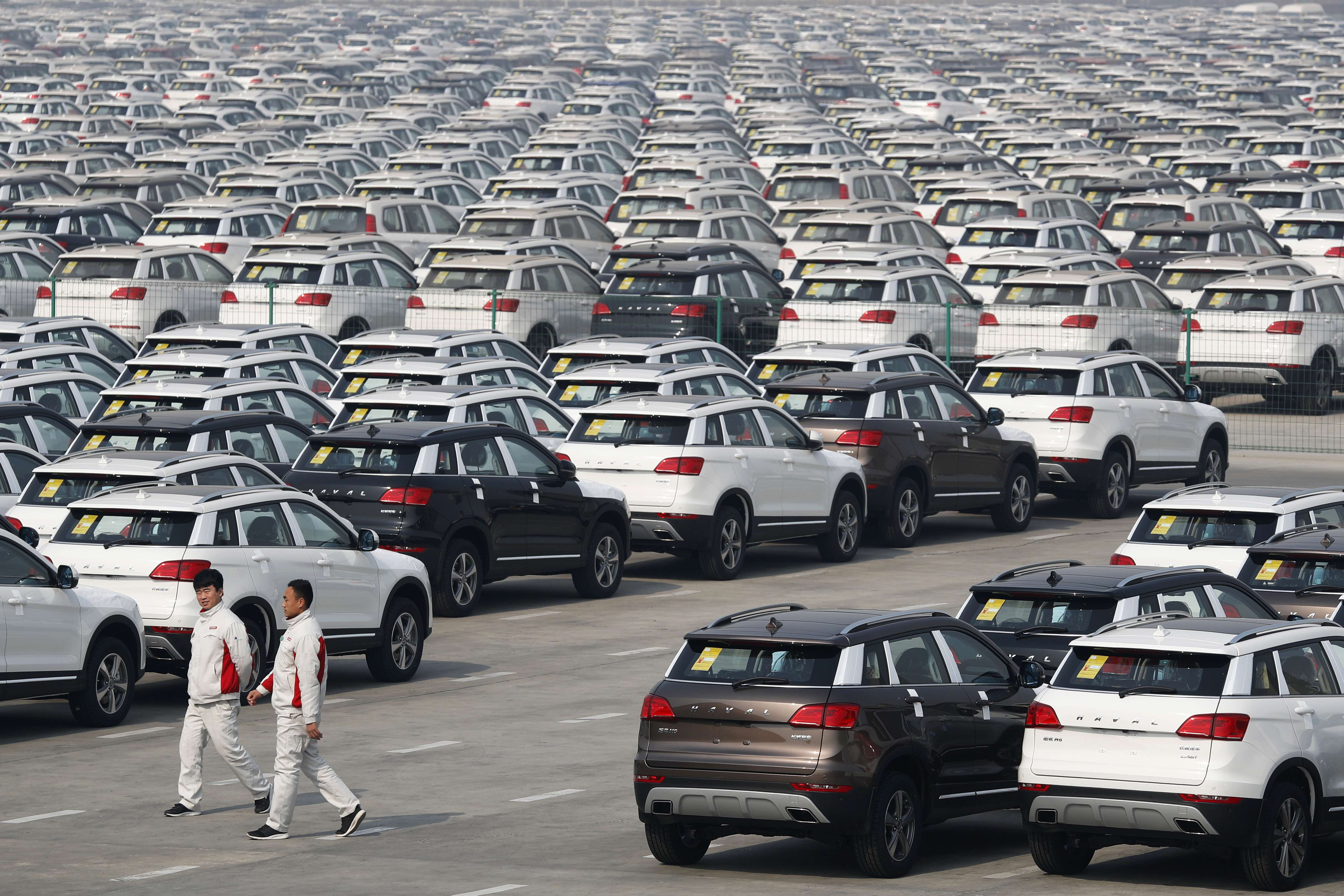 Workers walk past Haval SUV models parked outside the Great Wall Motors assembly plant in Baoding, Hebei province. Output of most industrial products rose compared with the same period last year, statistics bureau chief Ning ­­Ji­zhe said. Photo: AP