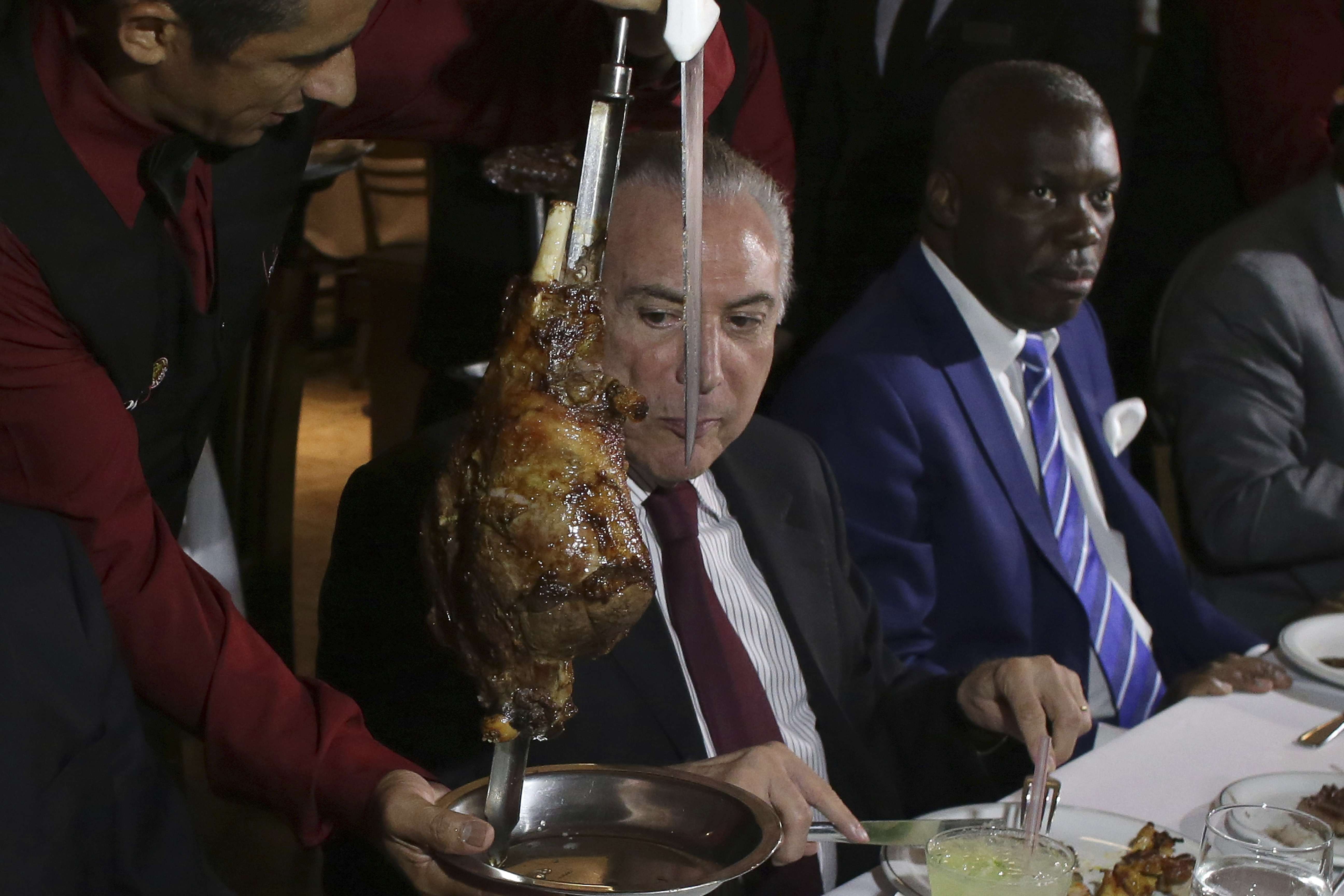 Brazilian President Michel Temer attends a steak dinner at a traditional Brazilian barbecue restaurant after a meeting on the rotten meat scandal. Photo: AP