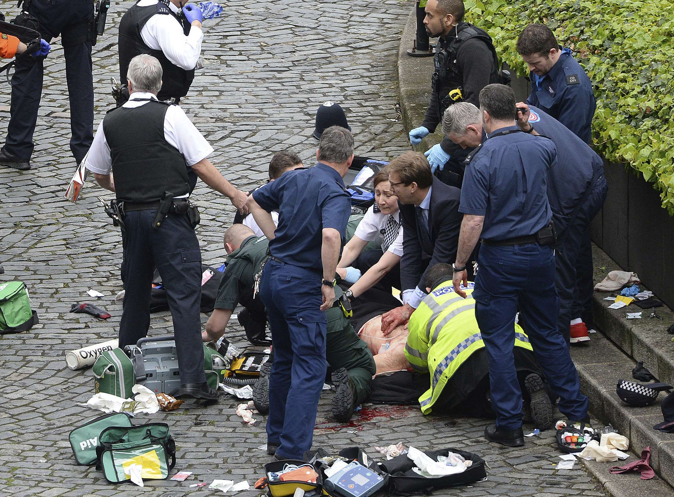 Conservative Member of Parliament Tobias Ellwood (centre, in suit) prvides first aid to police officer Keith Palmer, who was stabbed in the terrist attack outside the UK parliament in London. Palmer did not survive. Photo: AP