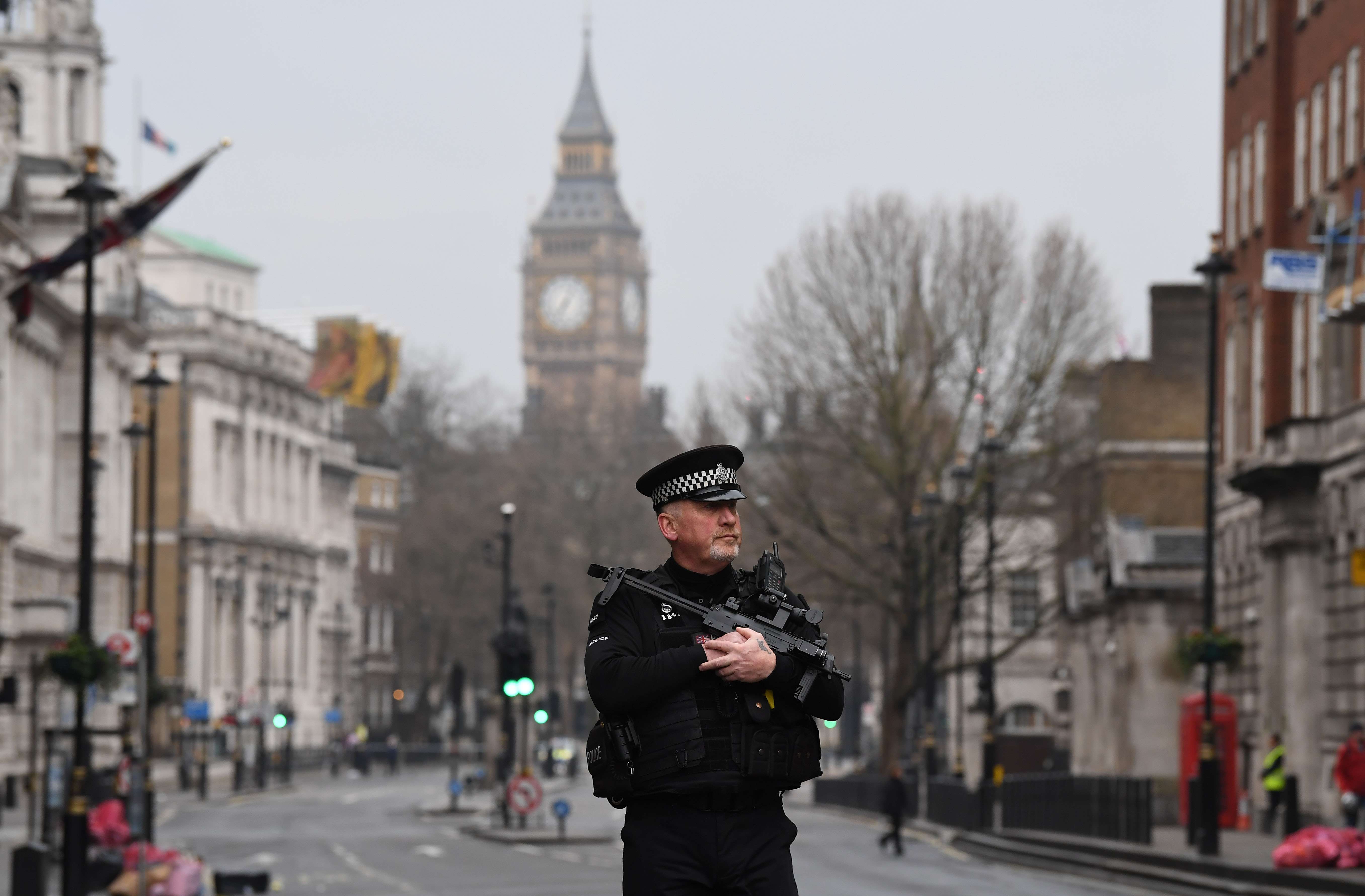 An armed police officer patrols a security cordon set up along Whitehall by the Houses of Parliament in London. Photo: AFP