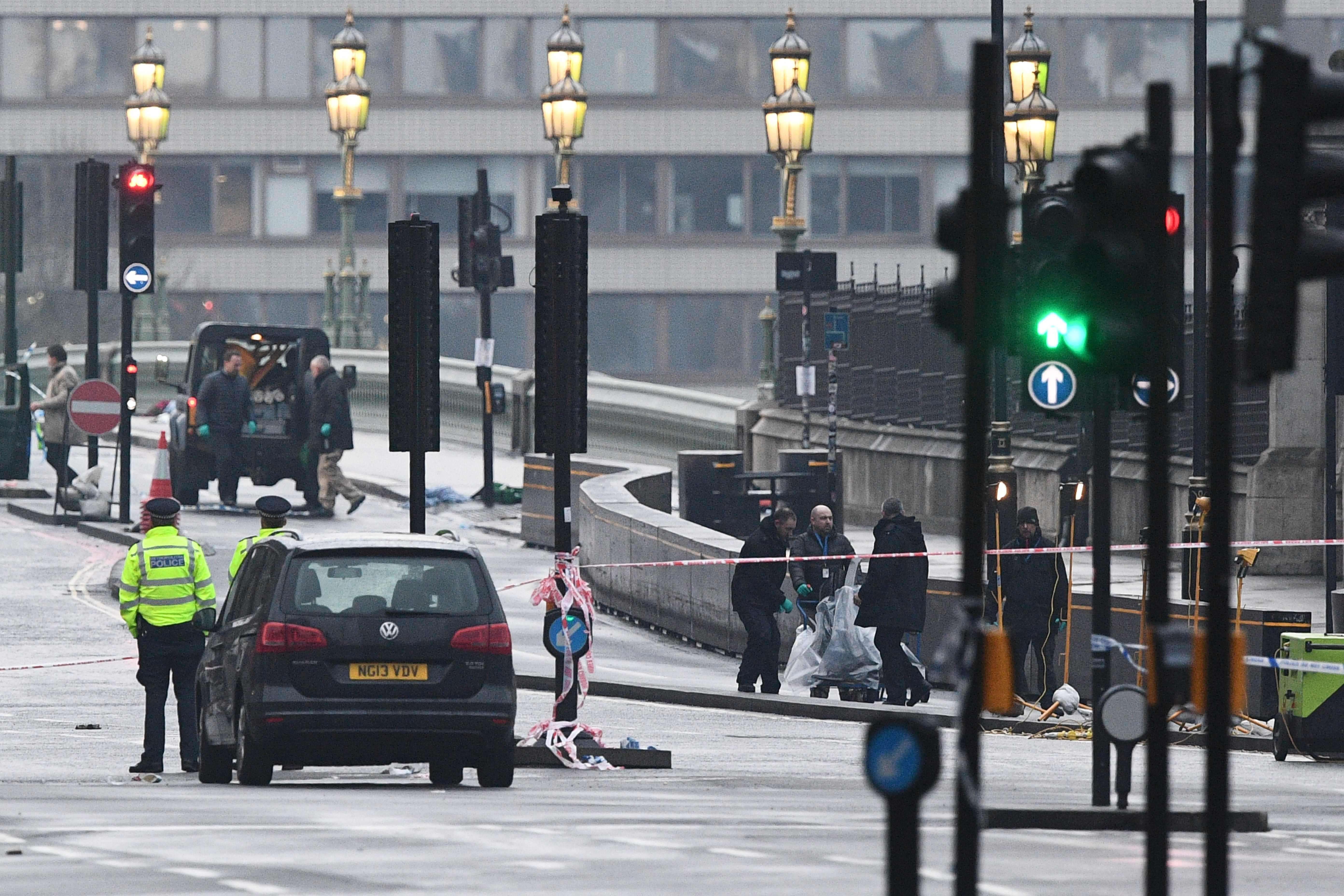 Security services staff collect debris left following the terror attack on Westminster Bridge. Photo: AFP