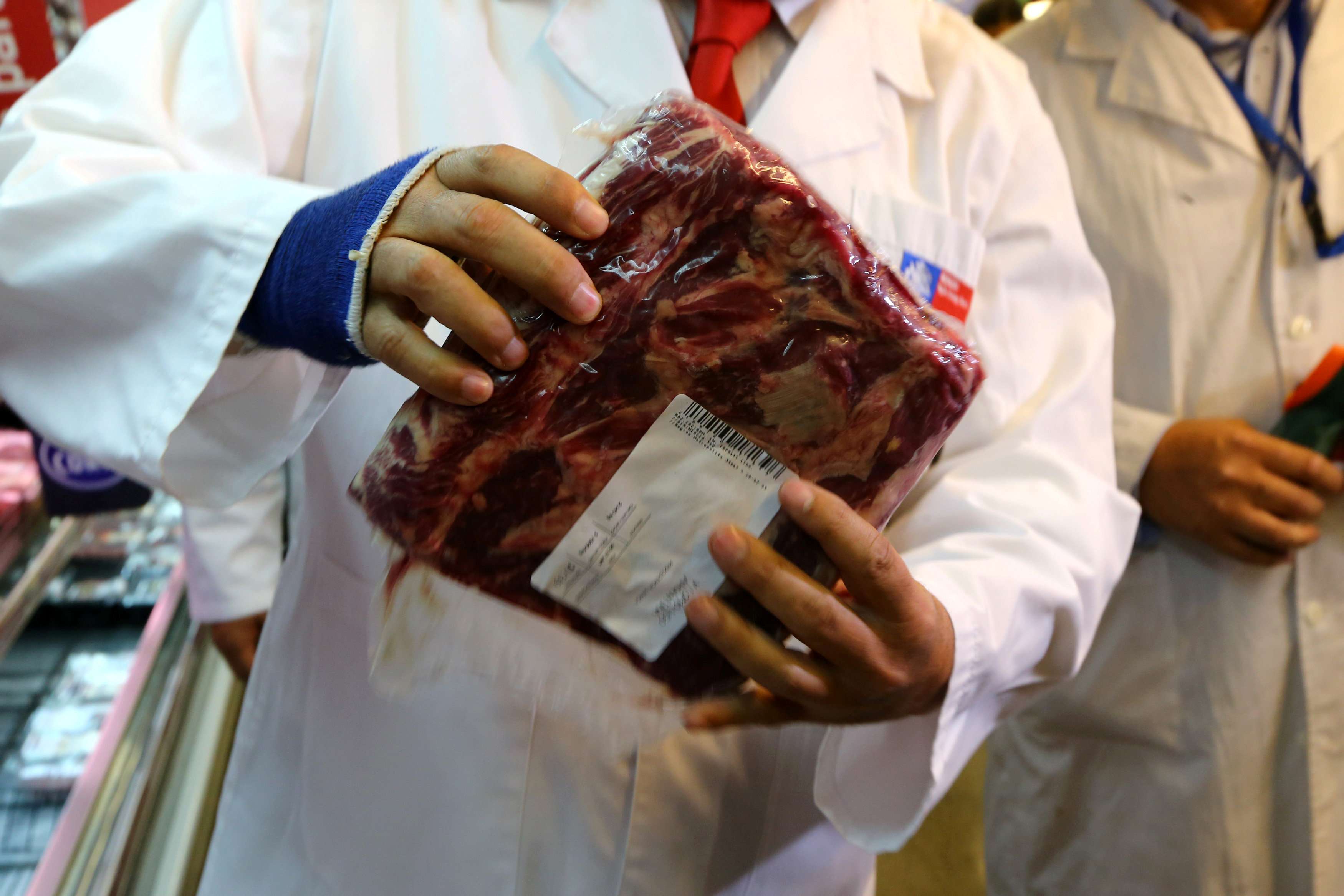A member of the Chile’s Public Health Surveillance Agency inspects a piece of beef. Photo: Reuters
