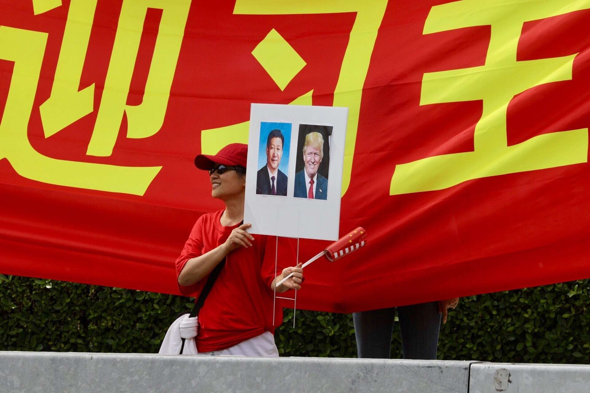 A supporter of President Xi Jinping stands on the street outside the Eau Palm Beach where Xi stayed during his summit with US President Donald Trump. Photo: AP Lannis Waters /Palm Beach Post via AP